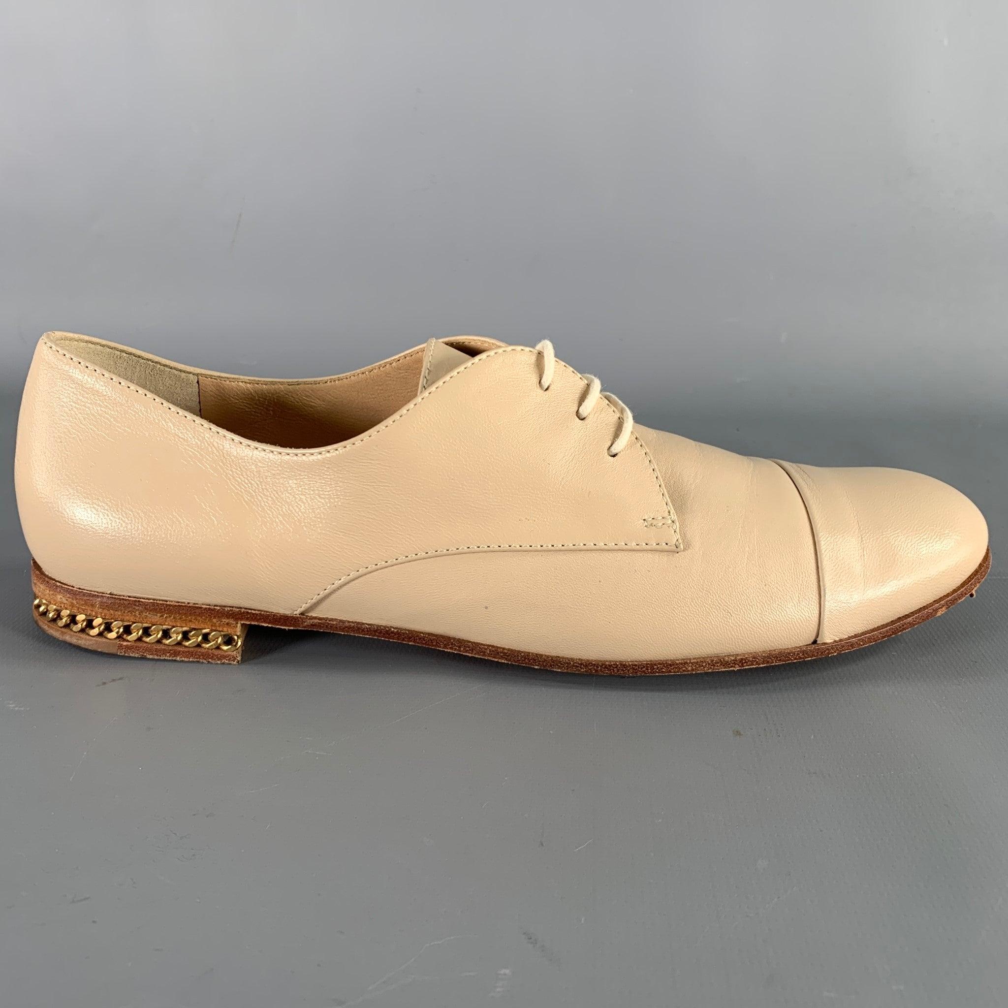 BALDININI shoes
in a beige leather featuring a derby style, gold tone metal chain heel detail, and lace-up closure. Made in Italy.Very Good Pre-Owned Condition. Minor signs of wear. 

Marked:   498015 37Outsole: 10 x 3.5 inches 
  
  
 
Sui Generis