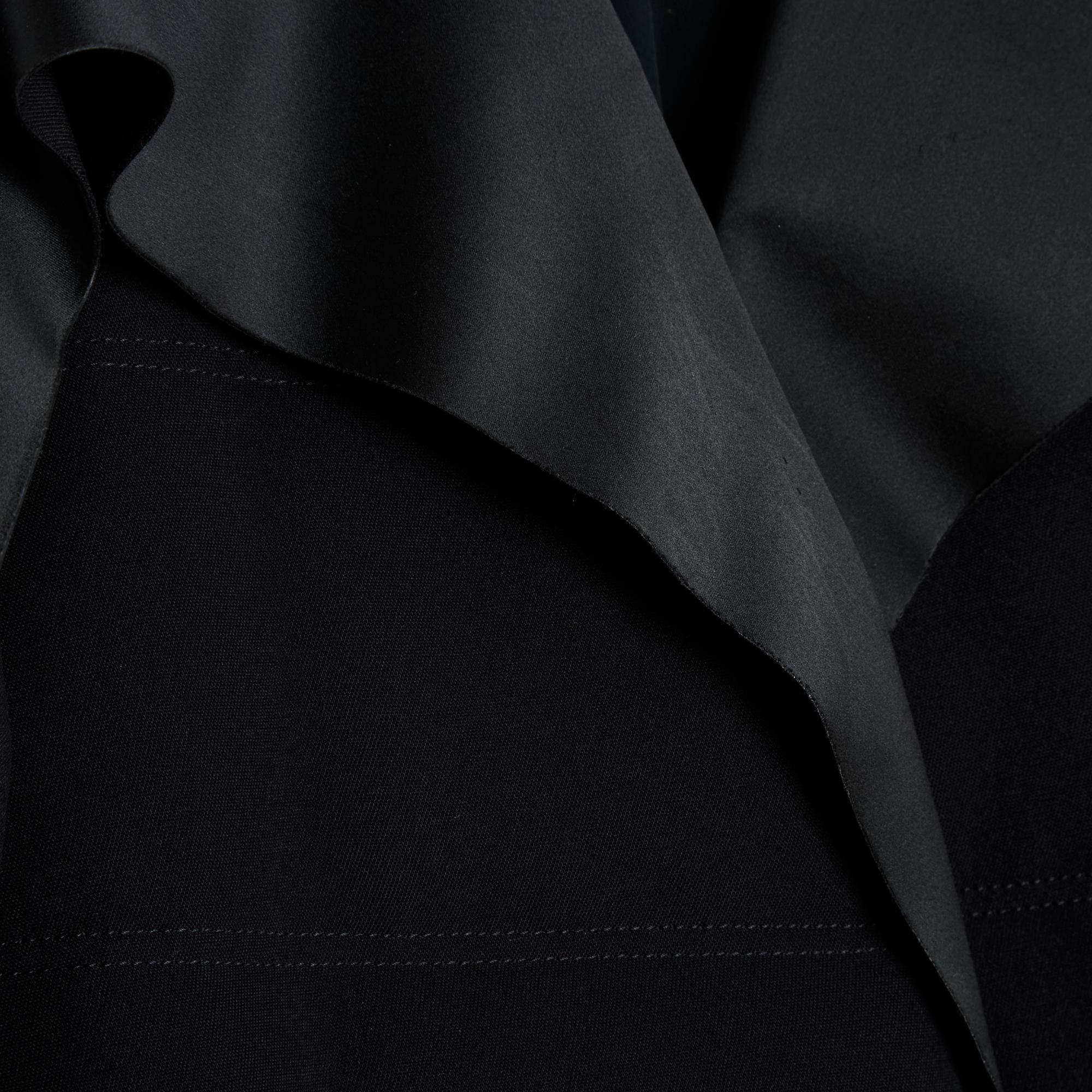 Balenciaga coat from the AH 2014 collection, down jacket style, in thick quilted black technical canvas, wide collar in thick satin canvas that continues along the entire front of the sleeves, raglan and long, front closure with a zip with a logo