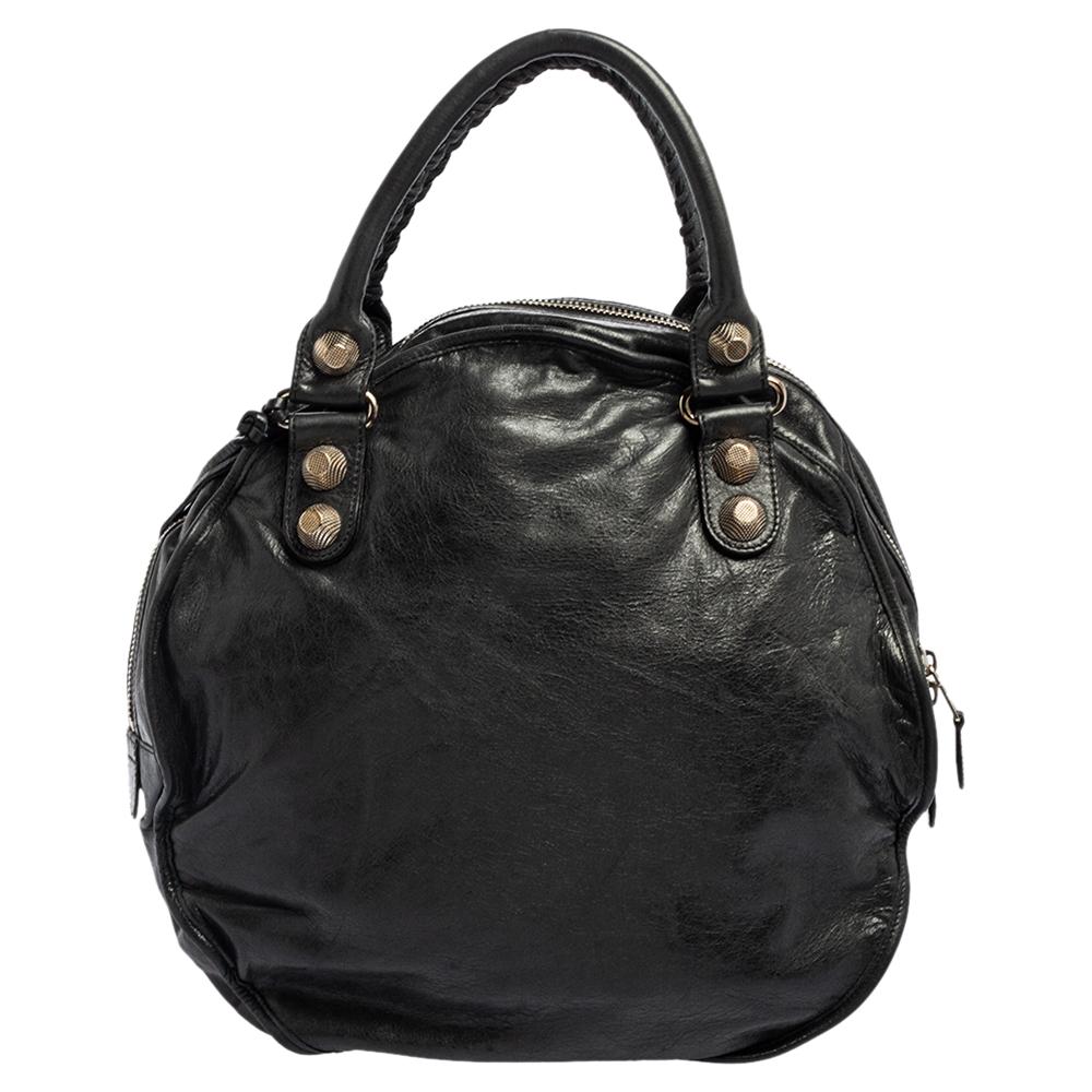 A popular bag among fashionistas, this Sphere bag by Balenciaga will never leave you unnoticed! It is crafted from leather in a round shape and is accented with oversized signature metal buckle and stud details. It comes with a spacious fabric-lined