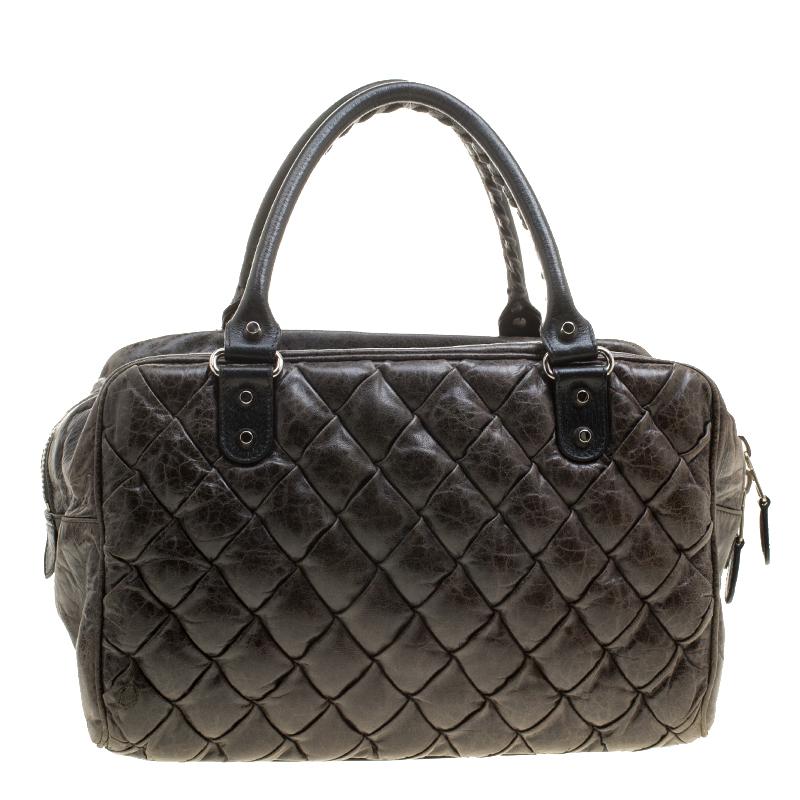 Super functional and modish, this Balenciaga satchel is a serious style elevator. It is crafted with Chevre leather featuring quilted pattern. It comes with a tasseled front zip pocket, a spacious interior lined with fabric, and double top handles