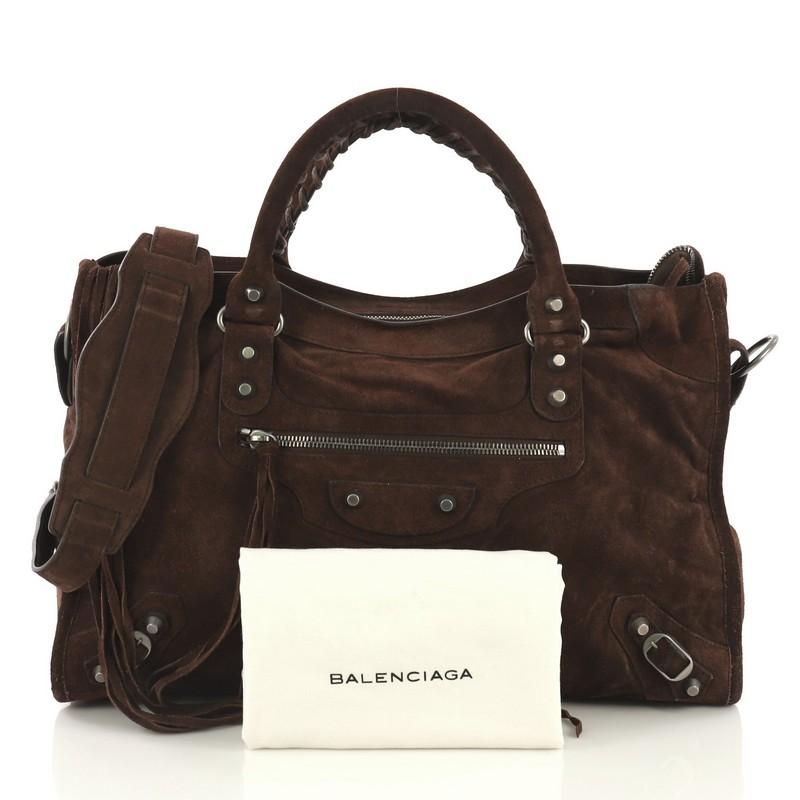 This Balenciaga Baby Daim City Classic Studs Bag Suede Medium, crafted in brown suede, features a front zip pocket and accented with braided hand-stitched handles, iconic Balenciaga classic studs and buckle details, and gunmetal-tone hardware. Its