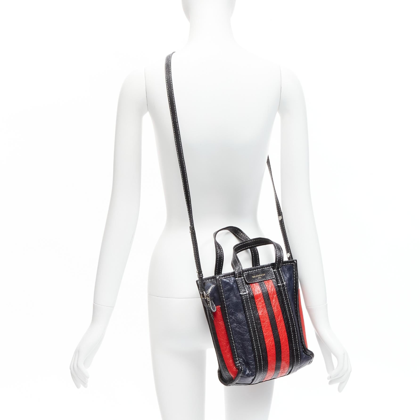 BALENCIAGA Bazar navy red striped leather top handle crossbody bag
Reference: JYLM/A00042
Brand: Balenciaga
Designer: Demna
Model: Bazar
Material: Leather
Color: Navy, Red
Pattern: Striped
Closure: Zip
Lining: Black Fabric
Extra Details: Leather