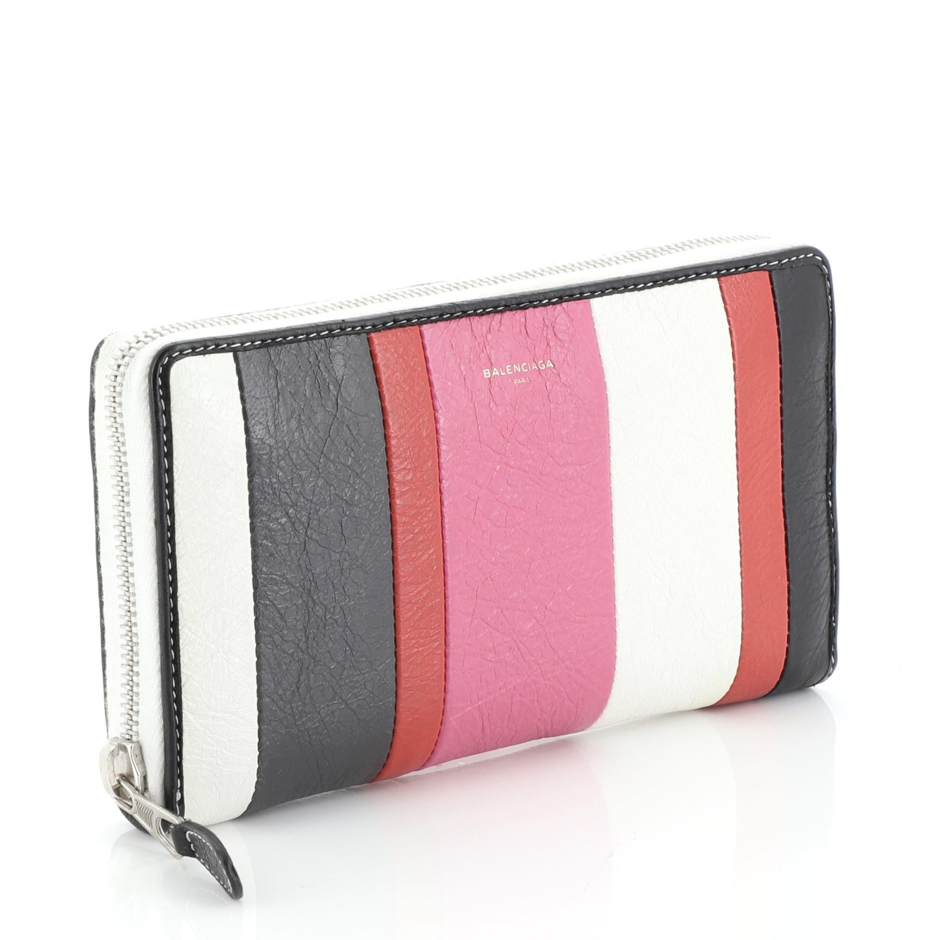 This Balenciaga Bazar Zip Wallet Striped Leather Long, crafted in white, red and multicolor leather, features silver-tone hardware. Its zip closure opens to a black leather and fabric interior with multiple card slots and zip pocket.

Estimated