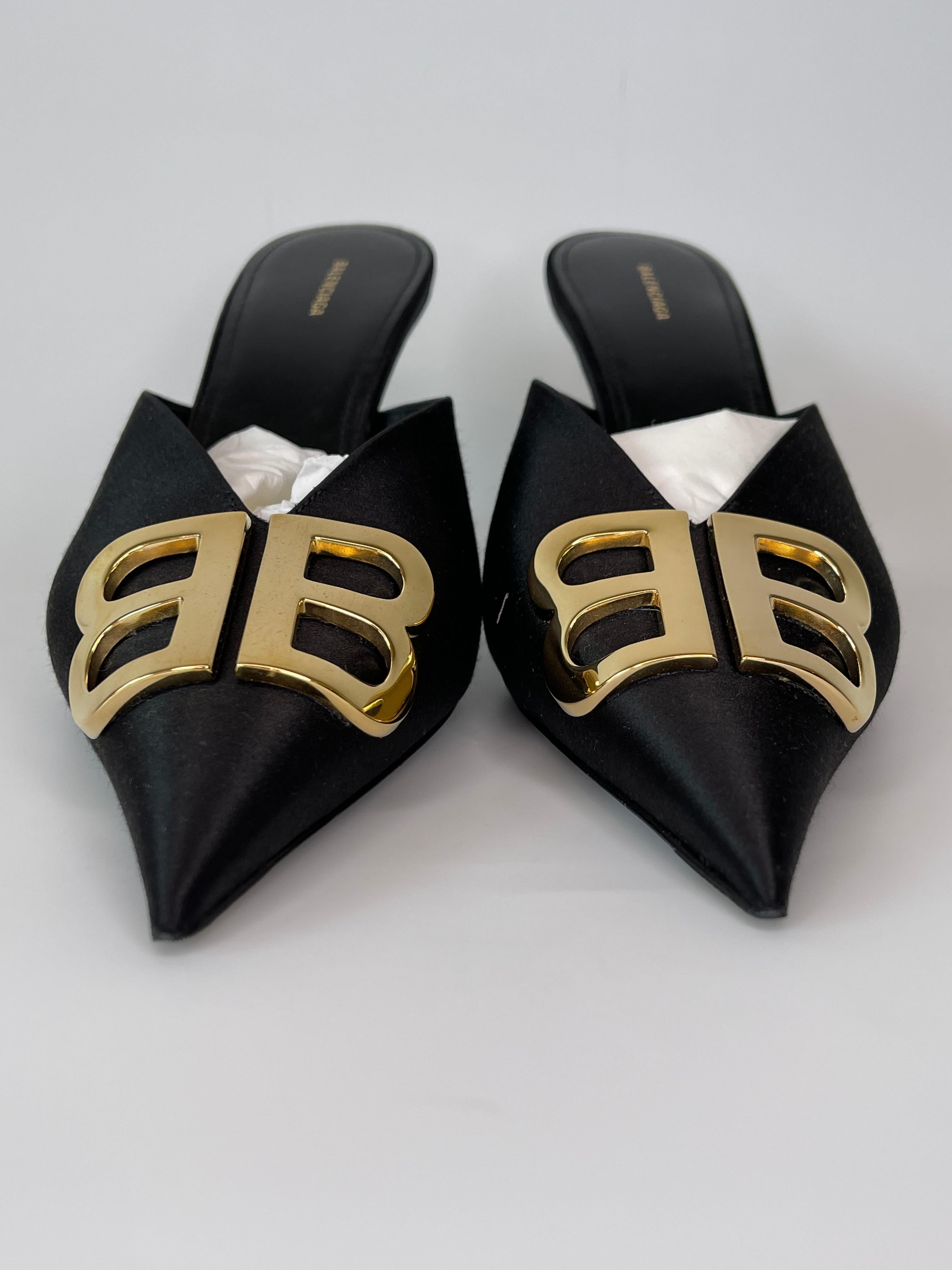 These pointed-toe mules are covered in black satin and feature the BB metal logo on the uppers, 80 mm (4 inch) heels, leather lining and a leather sole. 

COLOR: Black
MATERIAL: Satin 
ITEM CODE: 566642 
SIZE: 40 EU / 9 US
HEEL HEIGHT: 80 mm /