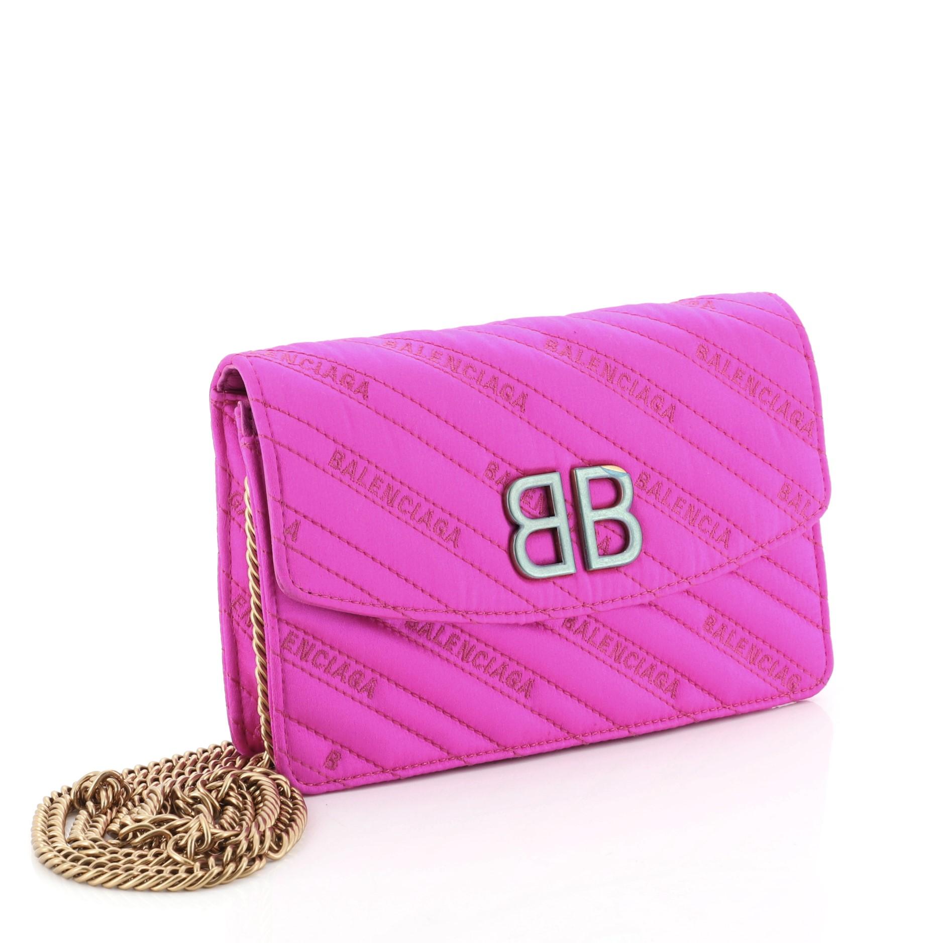 This Balenciaga BB Chain Wallet Quilted Satin, crafted from pink quilted satin, features chain link strap, BB logo on the flap and gold-tone hardware. Its flap opens to a pink leather interior with multiple card slots and zip pocket. 

Estimated