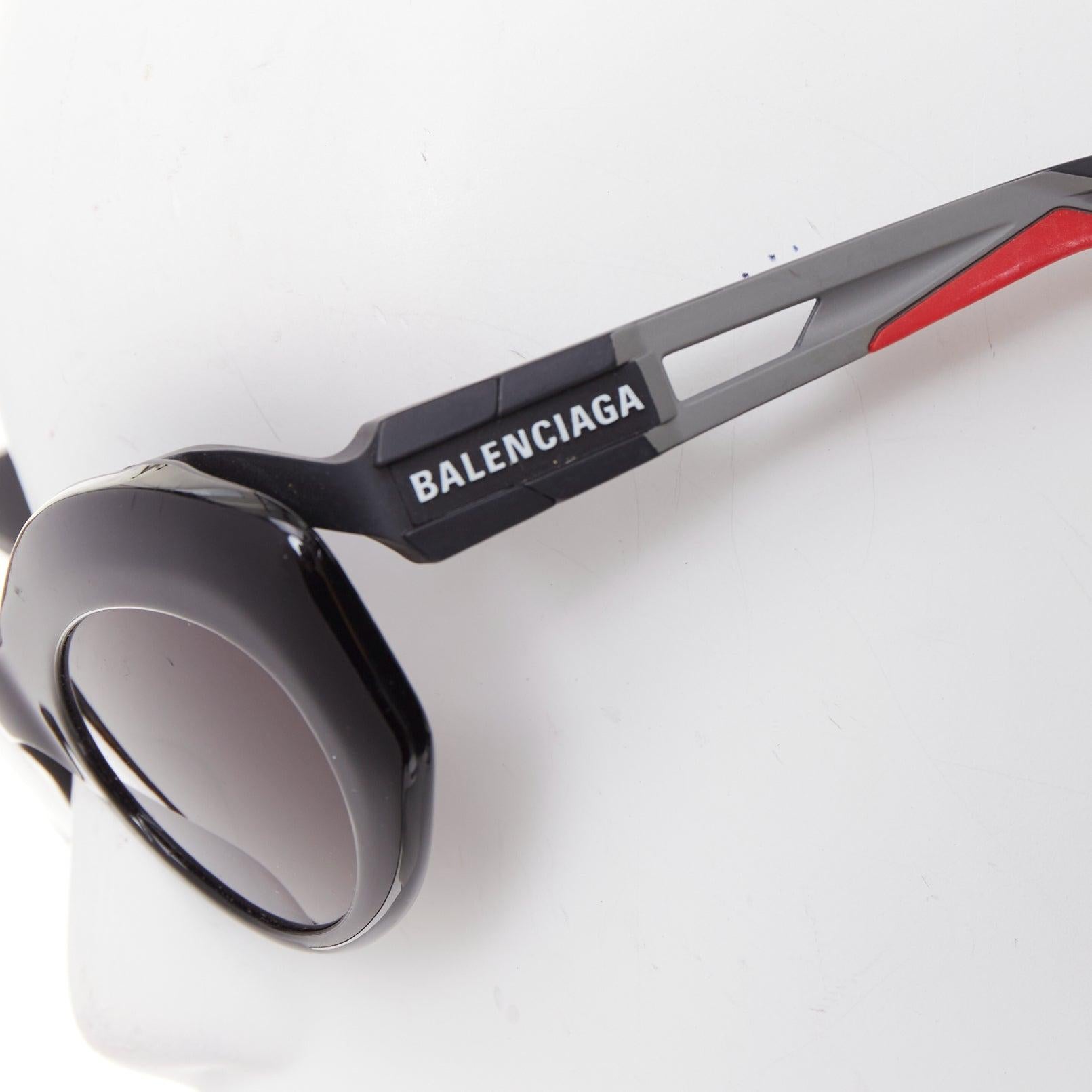 Occhiali da sole Balenciaga BB0053S Hybrid Oval nero grigio sportivo con aste in gomma
Riferimento: TGAS/F00166
Marchio: Balenciaga
Designer: Demna
Modello: BB0053S
Collezione: AW2019
Materiale: Acetato, gomma
Colore: Nero, Grigio
Modello: Tinta