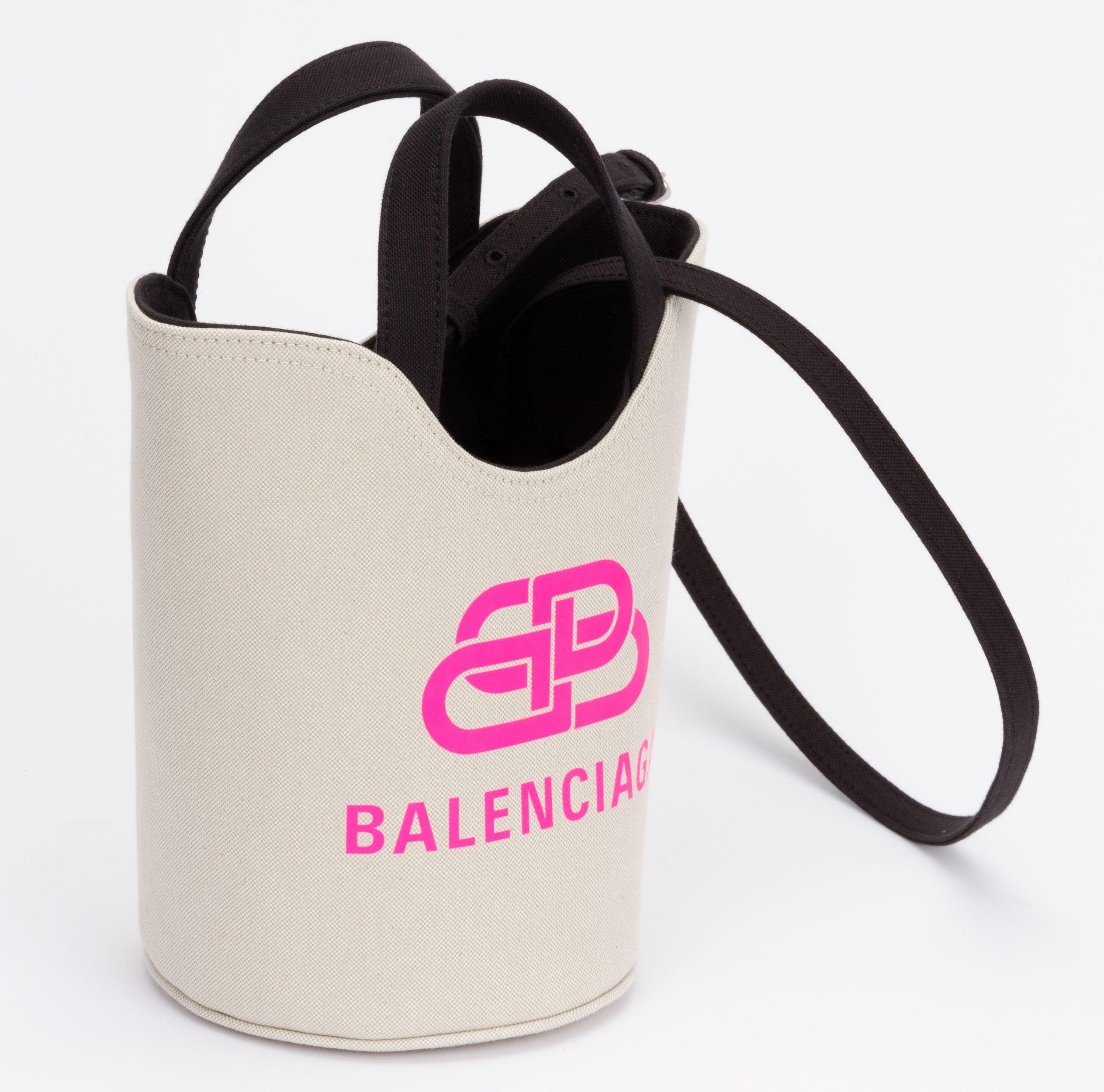 Balenciaga new beige bucket bag with black details and pink front logo. Comes with adjustable and detachable shoulder strap (drop 18.5