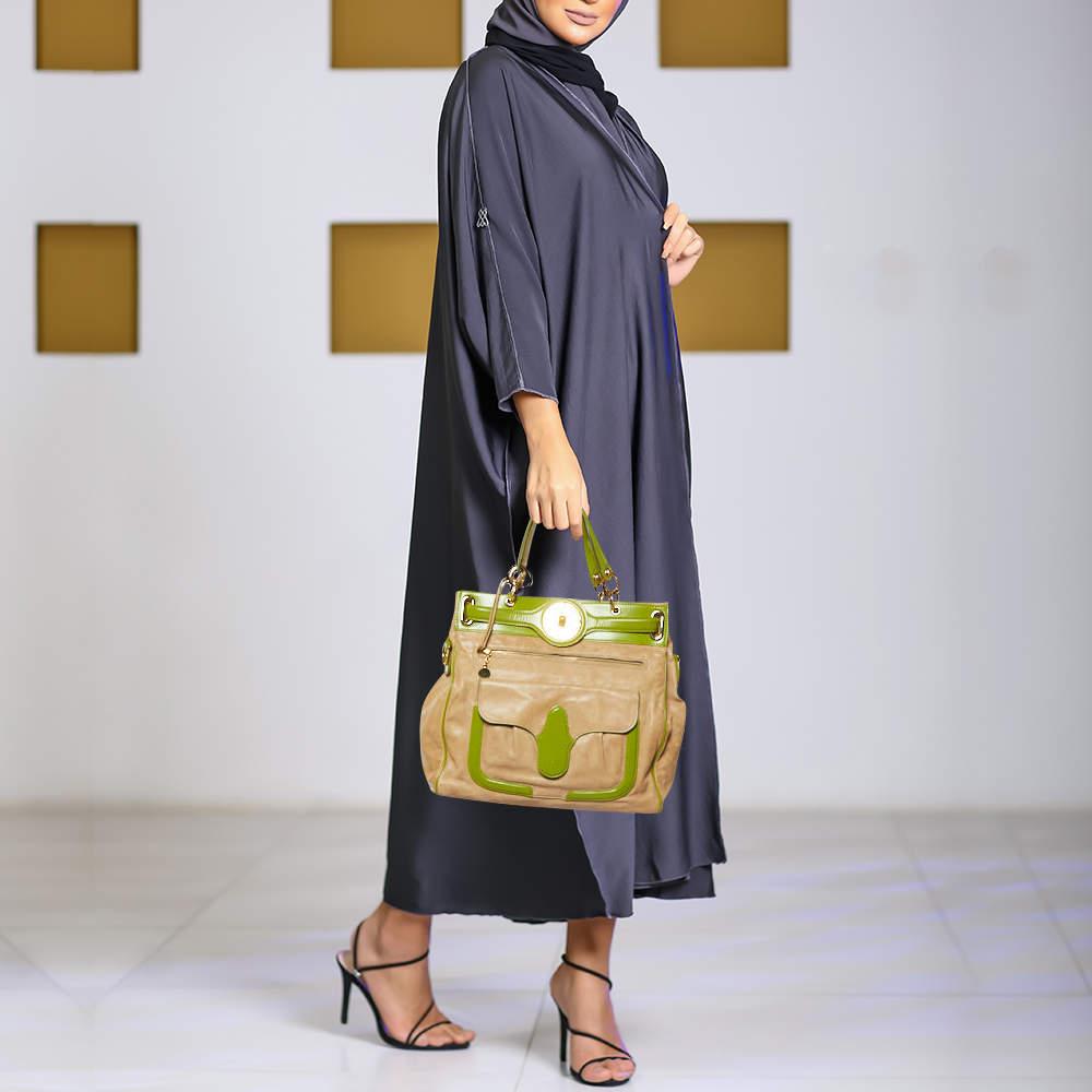 Ideal for everyday use this Balenciaga Lune tote is crafted from green and beige leather. The bag features dual handles a front zip pocket and a front flap pocket. The lock closure opens to a fabric lined interior that is equipped with enough space