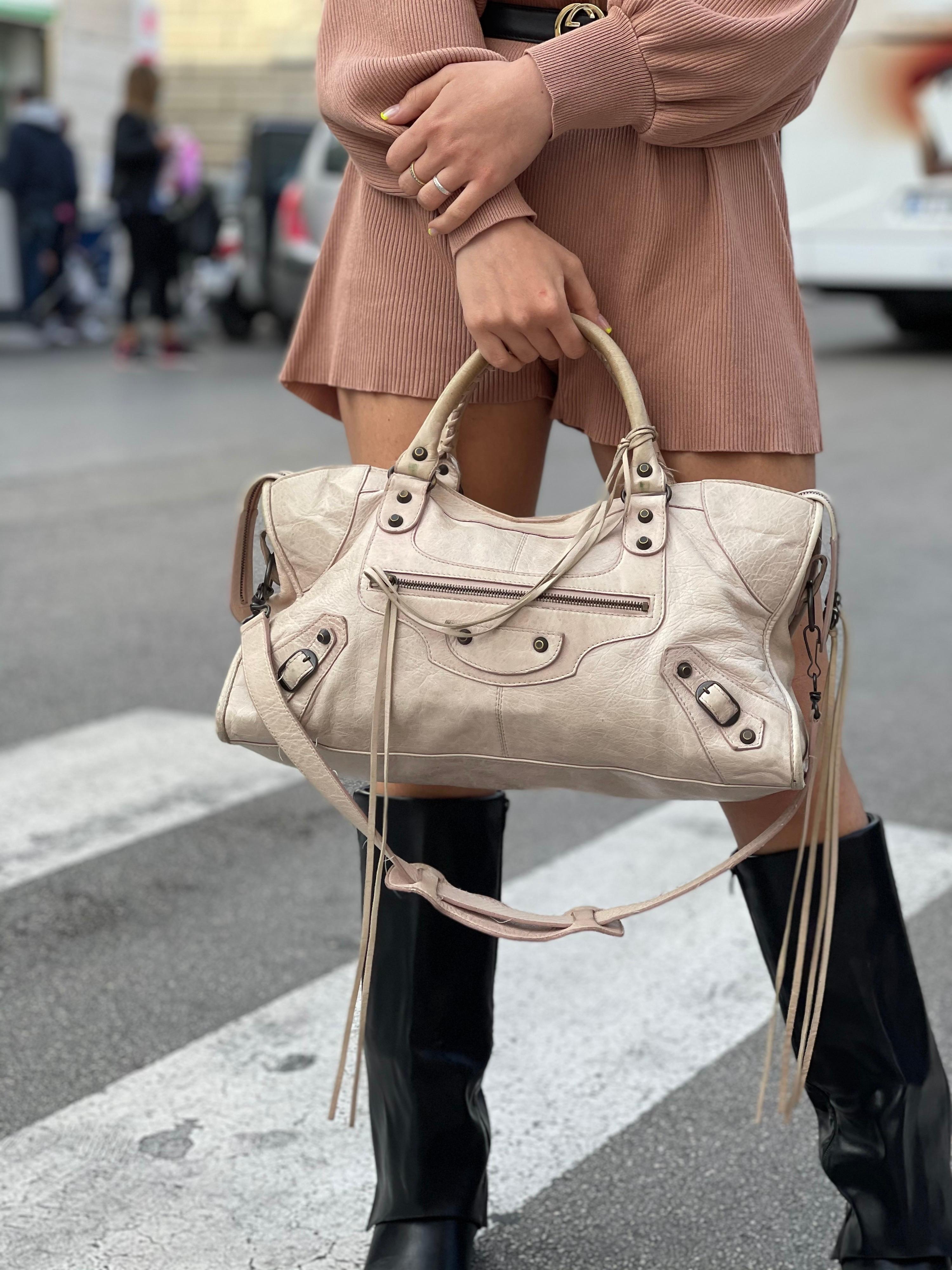 Balenciaga designer bag crafted in beige leather with black hardware.
Zip closure, very large inside. Equipped with double leather handle and shoulder strap. The bag is in good condition.