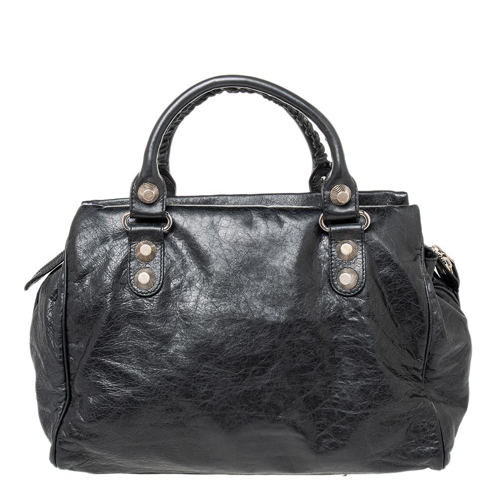 A popular bag among celebrities, this Midday bag by Balenciaga will never leave you unnoticed! It is crafted from leather and is accented with oversized signature metal buckle and stud details. It comes with a spacious fabric-lined interior with one