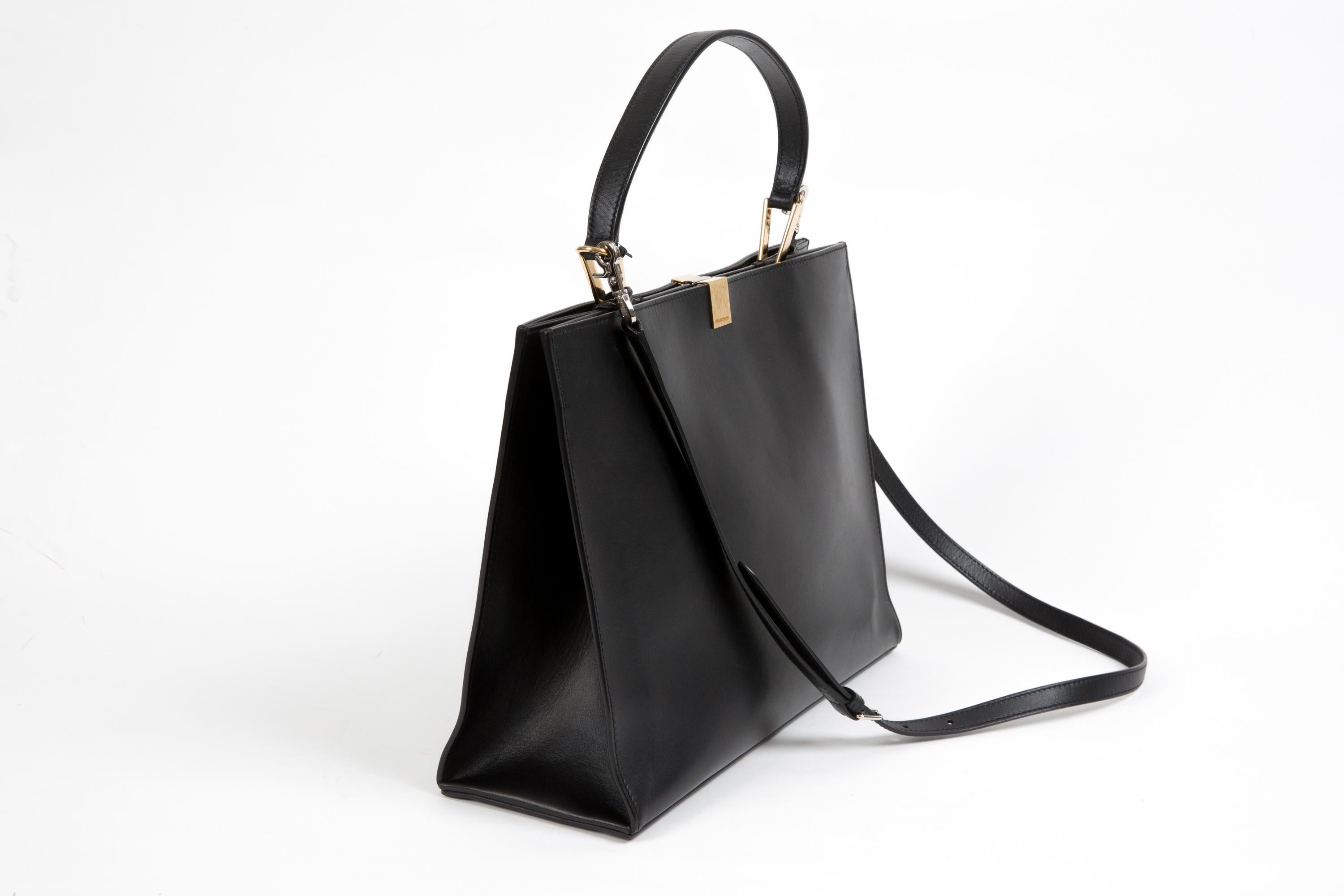 Balenciaga Black calfskin leather handbag “Le Dix” featuring a removable shoulder/crossbody strap (41.3in. (105cm)), mix gold and silver hardware, a top claps closure, inside compartments zipper and slip pockets. 
Circa 2010s 
In good vintage