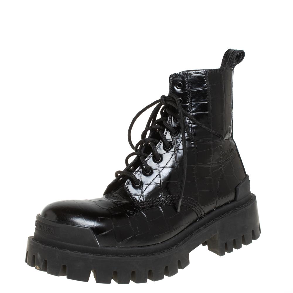 Made from black croc-embossed leather, this pair of L20 Strike booties by Balenciaga is a statement style to wear endlessly. They're made in Italy and features lace-up closure along the front, pull tabs, and round toes. The high soles add an