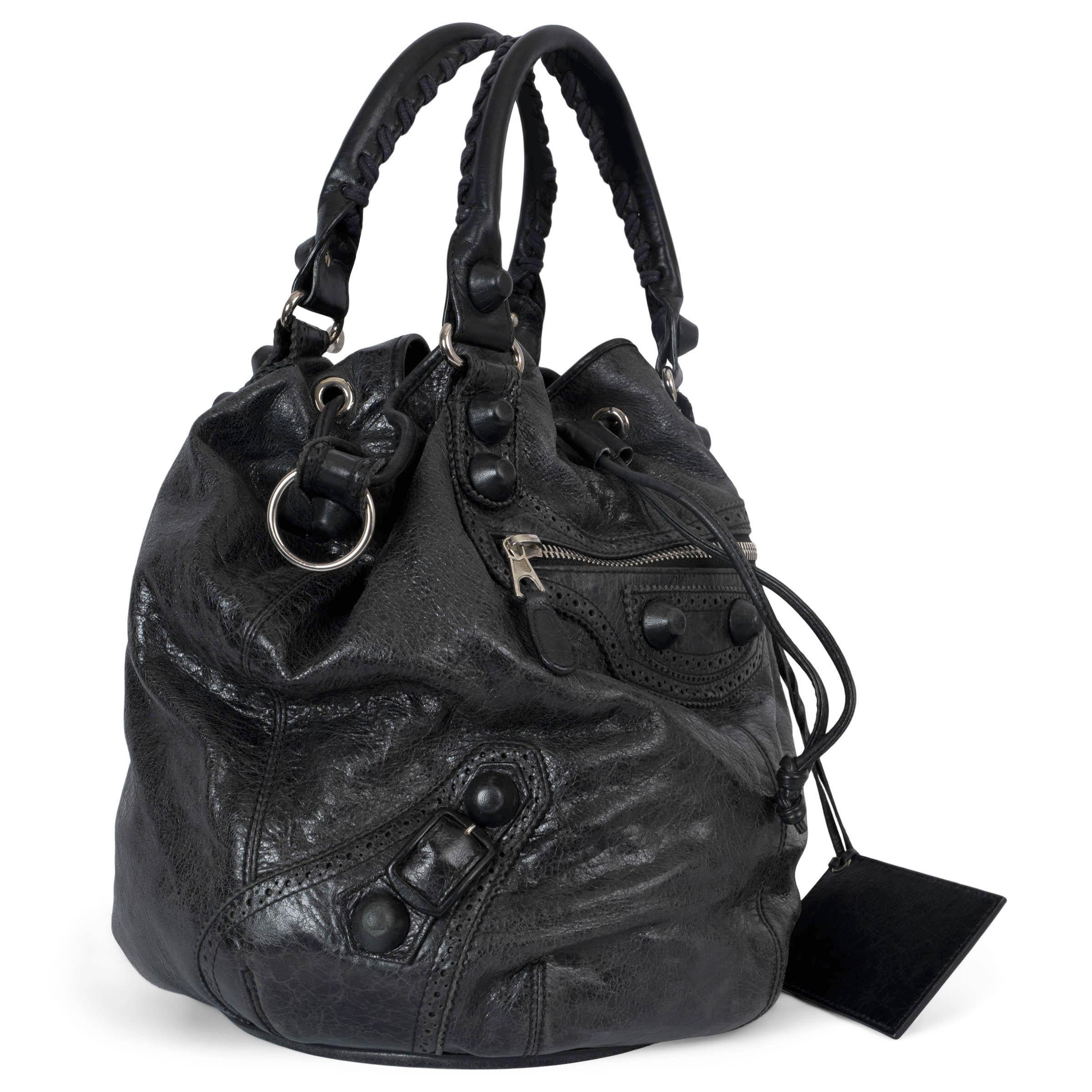 100% authentic Balenciaga Giant Brogue Pompon hobo bag in charcoal distressed leather featuring silver-tone hardware. The design is made functional with a drawstring closure, detachable shoulder strap, a front zipper pocket, dual handles, and a