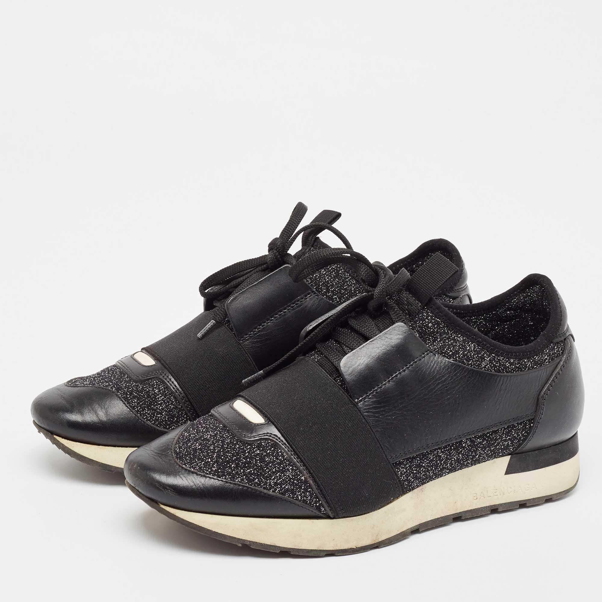 Let your latest shoe addition be this pair of Race Runners sneakers from Balenciaga. These black sneakers have been crafted from fabric and leather. They flaunt covered toes strap detailing on the vamps and tie up fastenings. They are complete with