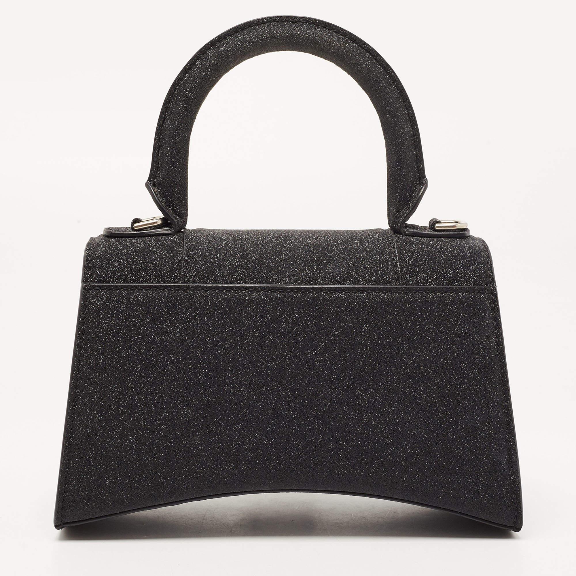 Balenciaga's Hourglass is inspired by the silhouettes of its sculptural blazers of the 1950s and, with its very distinctive shape, knows how to start a conversation. The curved bottom of this glitter construction is beautifully paralleled with the