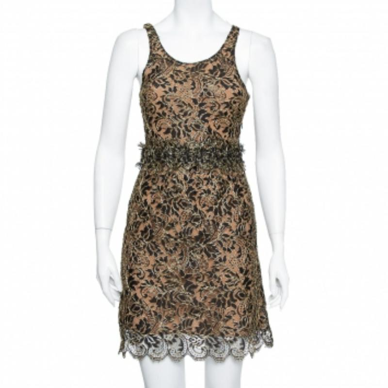 A sleeveless mini dress with a lace overlay makes up the final design of this Balenciaga creation. Beautiful in black and gold, the dress has a defined waistline, a scalloped hemline, scoop neckline, and zip closure.