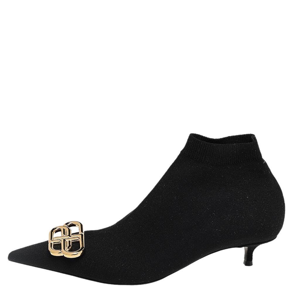 Carved in a sleek silhouette and augmented with distinct gold-toned hardware, these booties from Balenciaga stand as a true testament to the brand's epochal skill. They are crafted using black knit fabric with a gold-toned embellishment, pointed