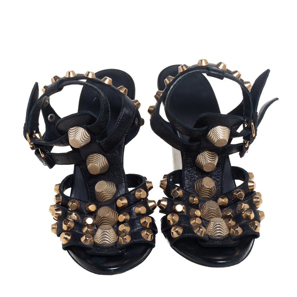 These stunning sandals by Balenciaga will make a statement. Crafted from leather, they come in black. These gladiator-style wedge heels feature straps embellished with gold-tone studs, buckle closure, 10 cm heels, and robust soles. They are stylish,