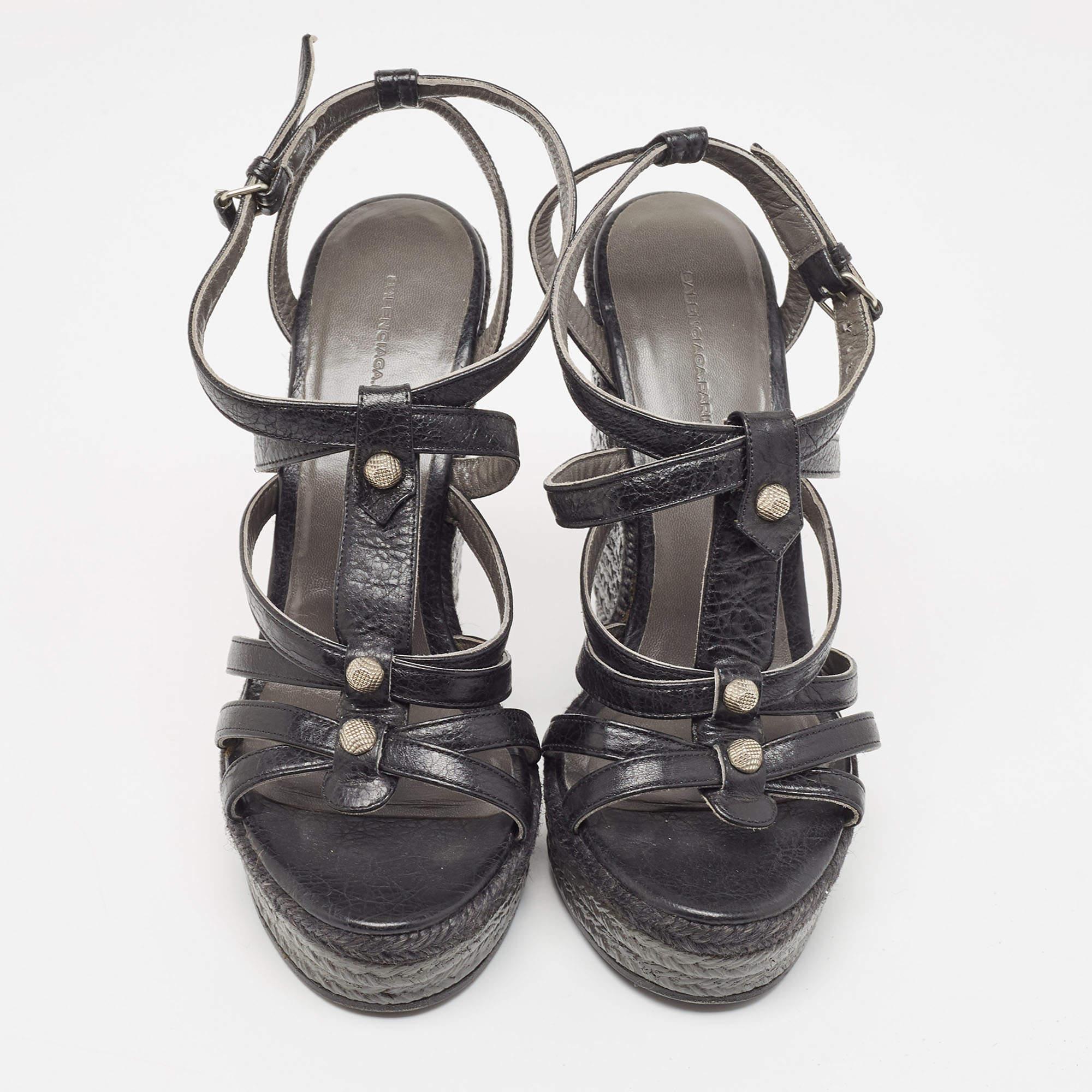 How lovely do these sandals from Balenciaga look! These black sandals are crafted from leather and feature an open toe silhouette. They flaunt a cage design with multiple silver-tone studs adorning the straps. Equipped with buckled ankle straps and