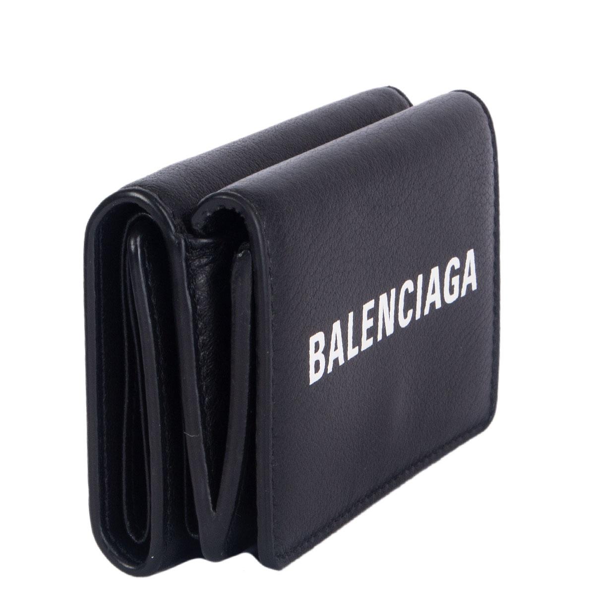 100% authentic Balenciaga Cash Mini Wallet in black smooth calfskin featuring white printed logo at front. Opens with 2 push-buttons and has 4 credit card slots, 1 bill compartment and one coin pocket. Has been carried and is is in excellent