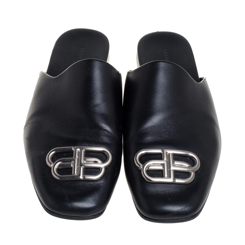 If you are an admirer of the latest fashion trends, this pair of Balenciaga mule sandals will add just the right vibe to your closet. The square-toe leather mules are covered in black and detailed with the BB metal symbol on the uppers and come with