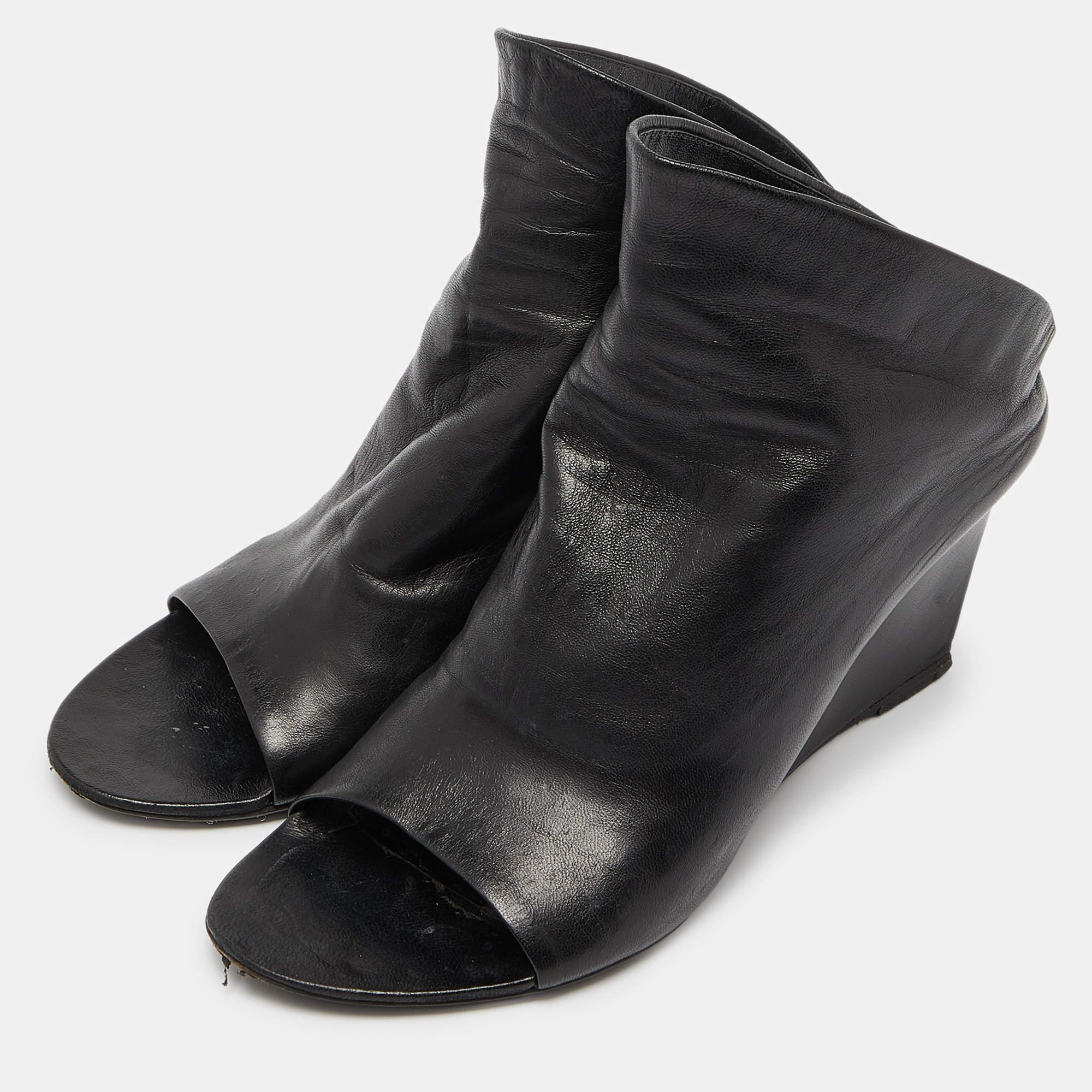 Introduce Balenciagas edgy style to your shoe collection with this pair of Glove wedge sandals. Crafted using black leather the pair features open toes wedge heels and leather lined insoles housing the brand label.
