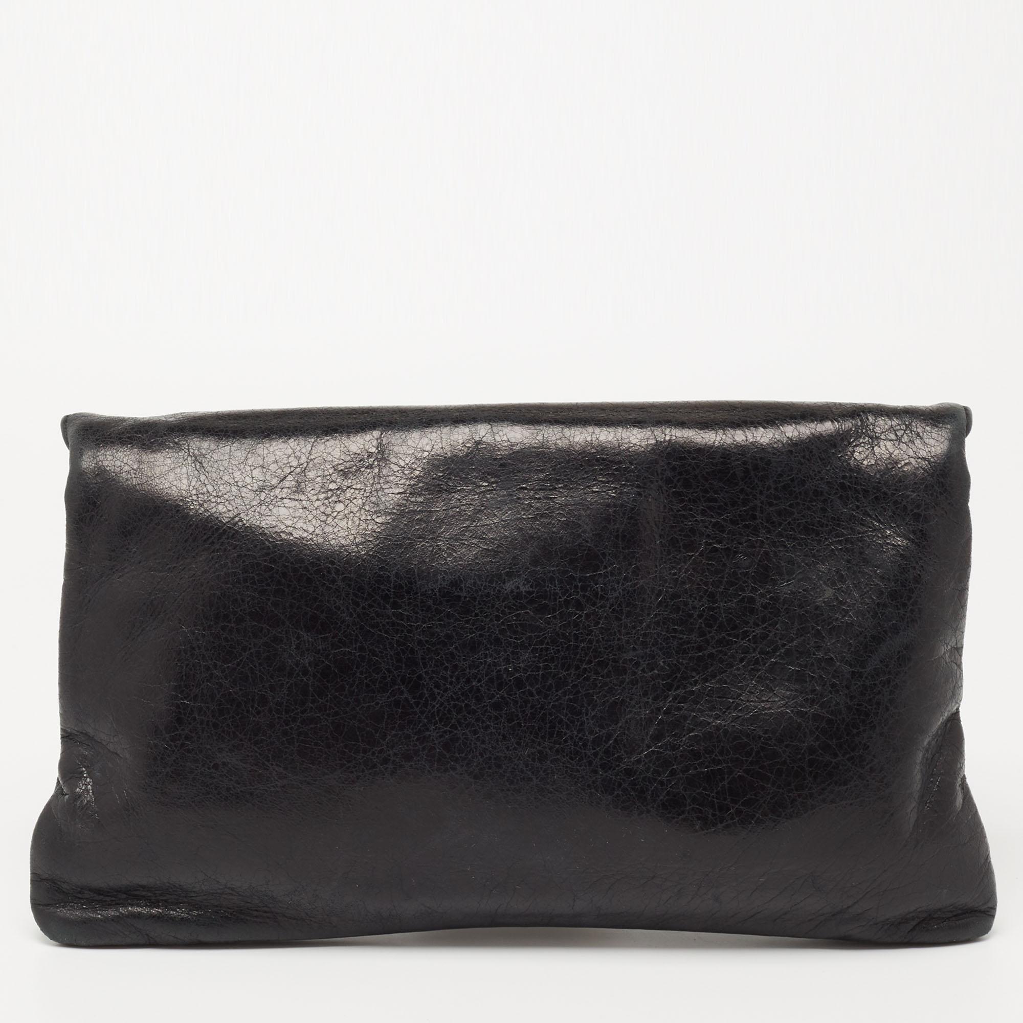 This Balenciaga clutch is as fancy as practical. Created from leather, the silver-tone studs make it undeniably chic and it flaunts an external zipper pocket on the folded top. The fabric-lined interior of this creation will comfortably carry your