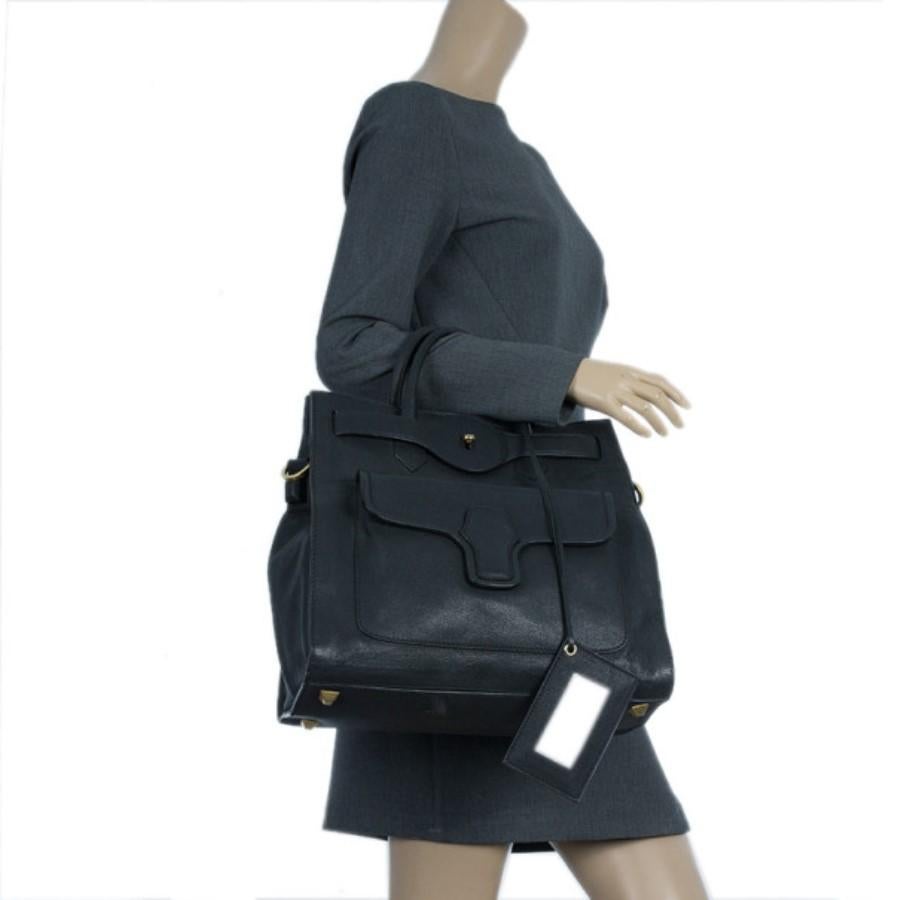 This bold and beautiful Balenciaga tote will make you all about the business. Made from leather, its black and structured exterior is designed with a double strap pin twist closure and double top handles. The front pocket has a magnetic flap closure