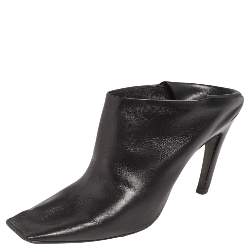 These impeccable Quadro mules from the House of Balenciaga have been created to frame your feet beautifully. Made from black leather on the exterior and flaunting square toes, these mules appear classic and stylish in every detail. They are placed
