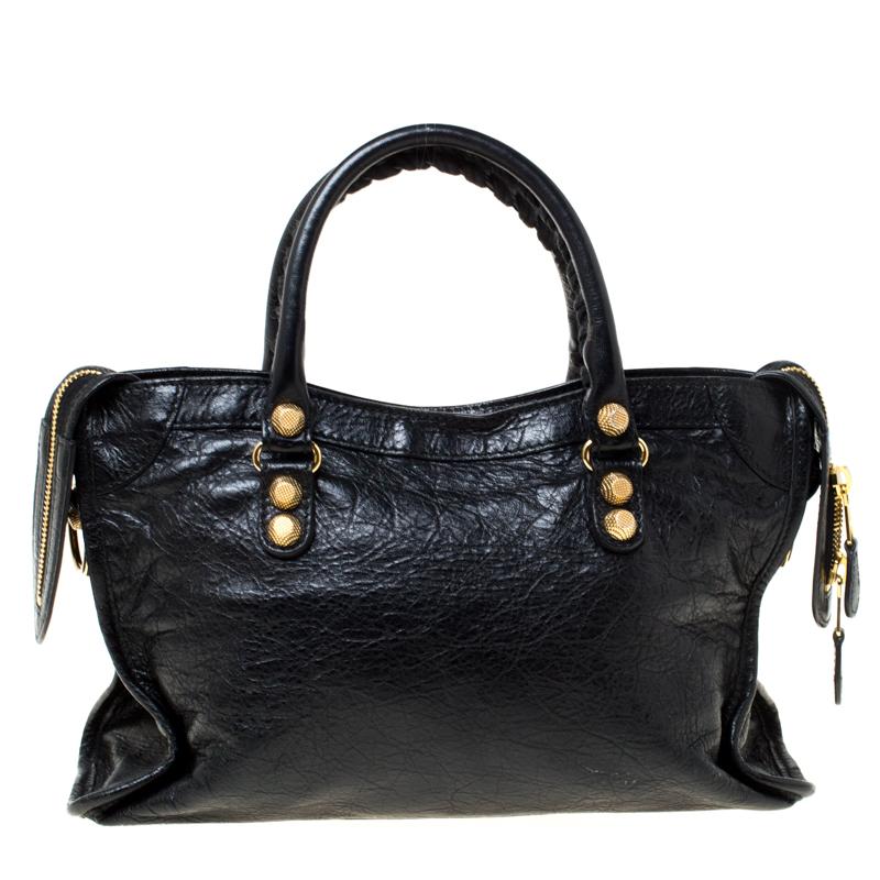 This Balenciaga City bag is perfect for everyday use. Crafted from leather, the bag has a feminine silhouette with two top handles and gold-tone hardware. The zipper closure opens to a fabric-lined interior and the bag is enhanced with buckles and a