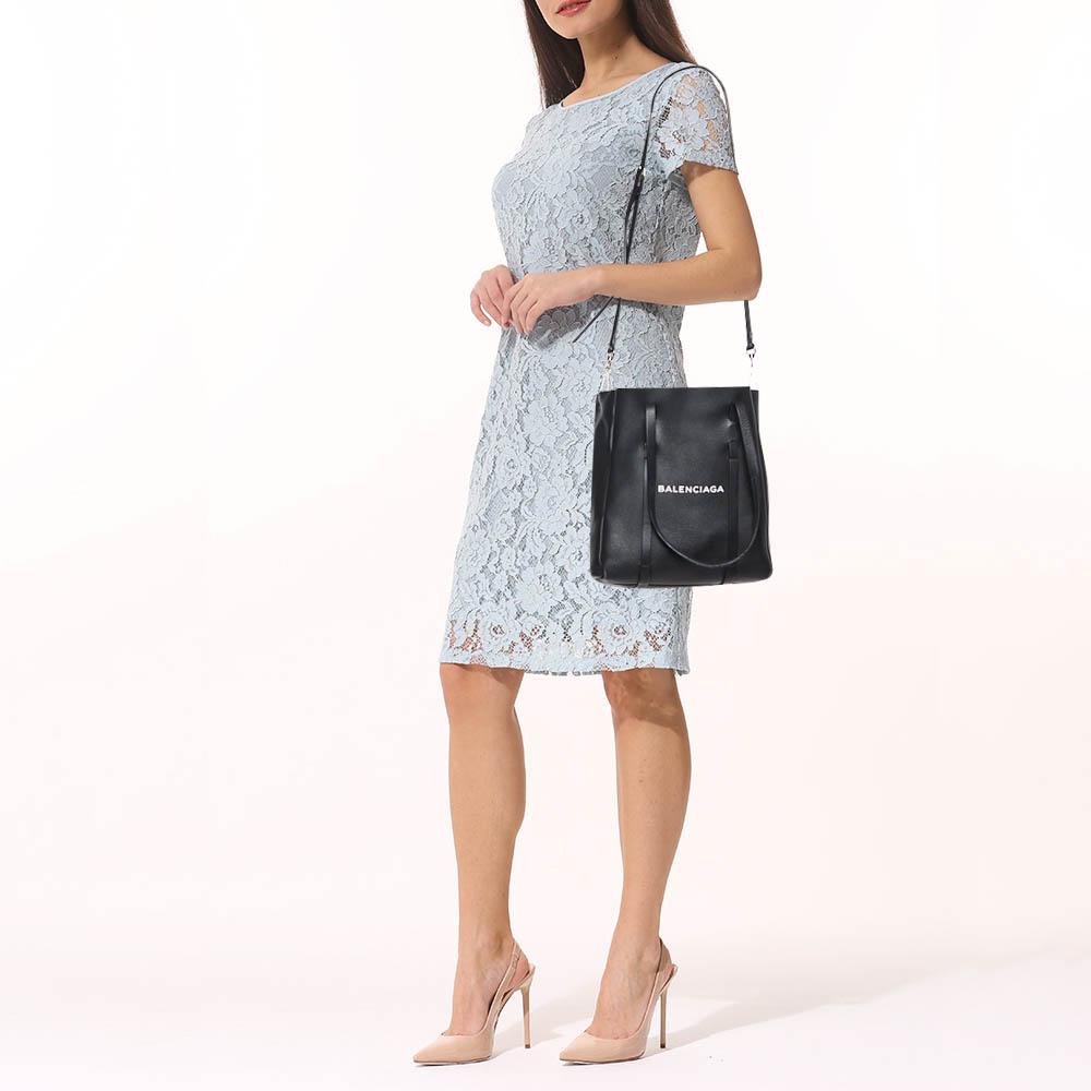 Balenciaga is known for its finely made handbags and this tote is one of them. Effortless and sleek, this black leather bag will be your go-to for multiple occasions. It has a smooth finish and a simple design that brings out the front logo. Two top