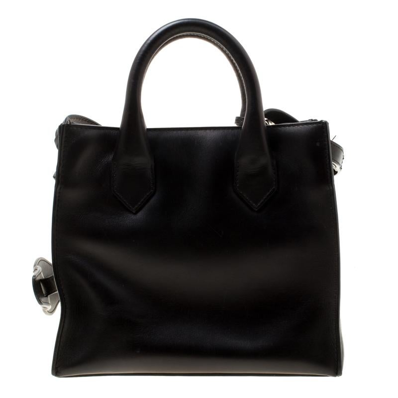 Make everyone nod in approval when you step out swinging this Balenciaga bag. Crafted from black leather the bag can be carried using the dual handles or the shoulder strap. It faults a flap pocket on the front, a leather key holder, gold-tone