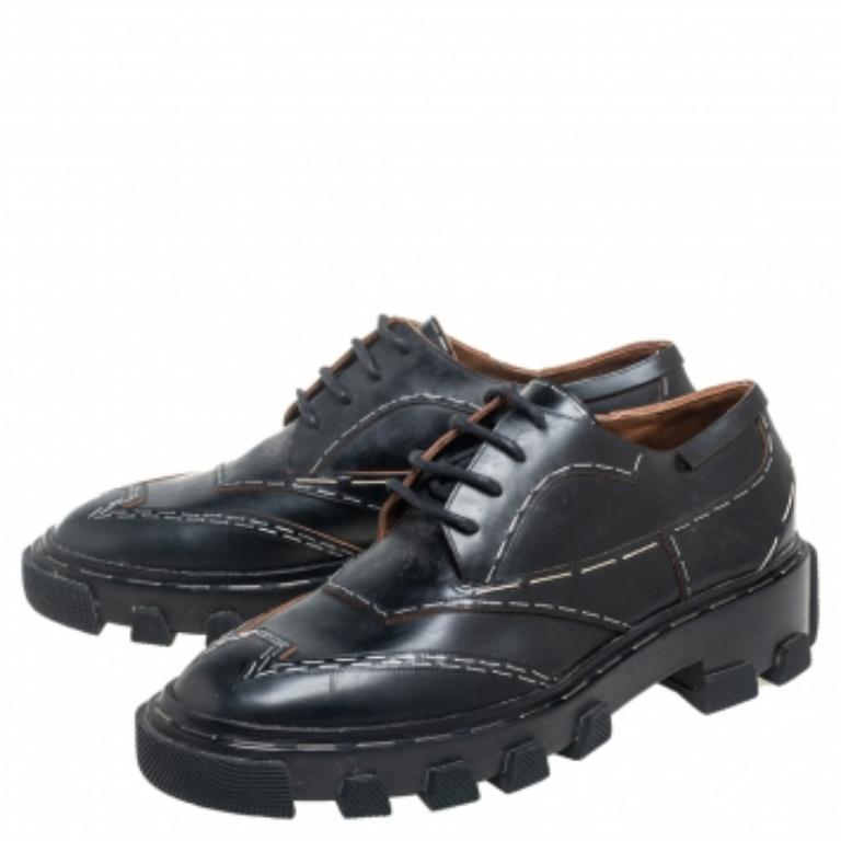 Donnez du relief à votre tenue en portant ces chaussures de la maison Balenciaga. Confectionnée en cuir, cette paire présente des bouts ronds, une empeigne à lacets et des détails de surpiqûres. Ils vous aideront certainement à exprimer votre style