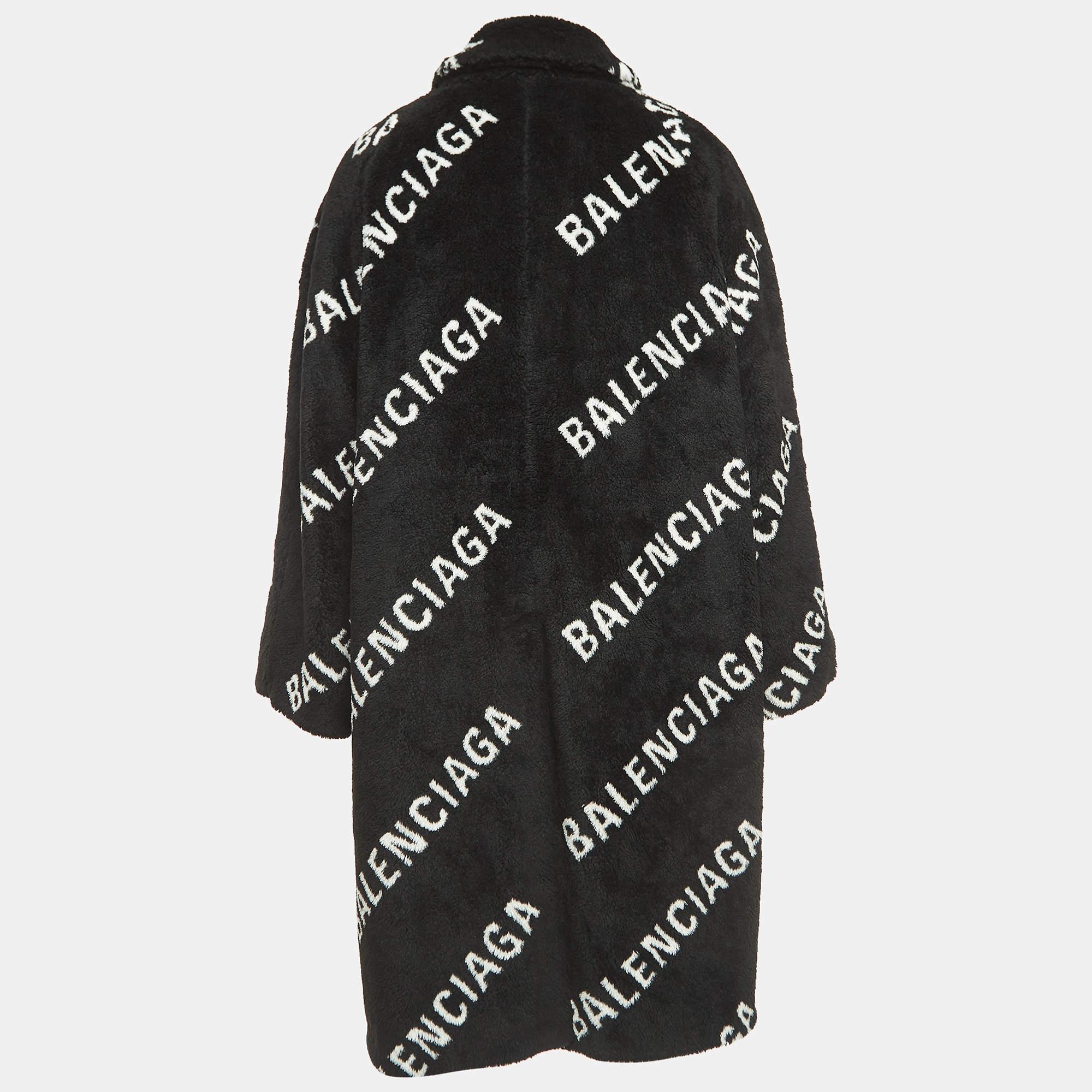 El abrigo Balenciaga irradia opulencia con su felpa de piel sintética y su distintivo estampado de monogramas. Su generosa silueta y su elegante tono negro son toda una declaración de moda, que garantiza tanto calidez como estilo de alta gama para