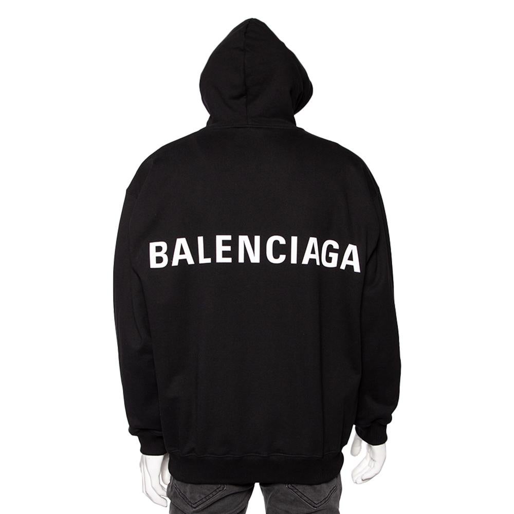 Get ready to exude signature charm and sophistication as you don this amazing hoodie from Balenciaga. Stitched using black cotton fabric, this sweatshirt flaunts a contrast logo print on the back and an oversized fit. It features one pocket.