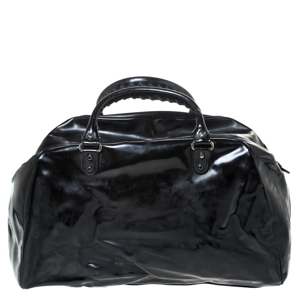 This Balenciaga Bowling bag is simply inimitable in its plush and modern design. The most attractive feature is its classic black color which enhances its appeal. It is crafted from patent leather and features a smooth exterior. It flaunts dual top