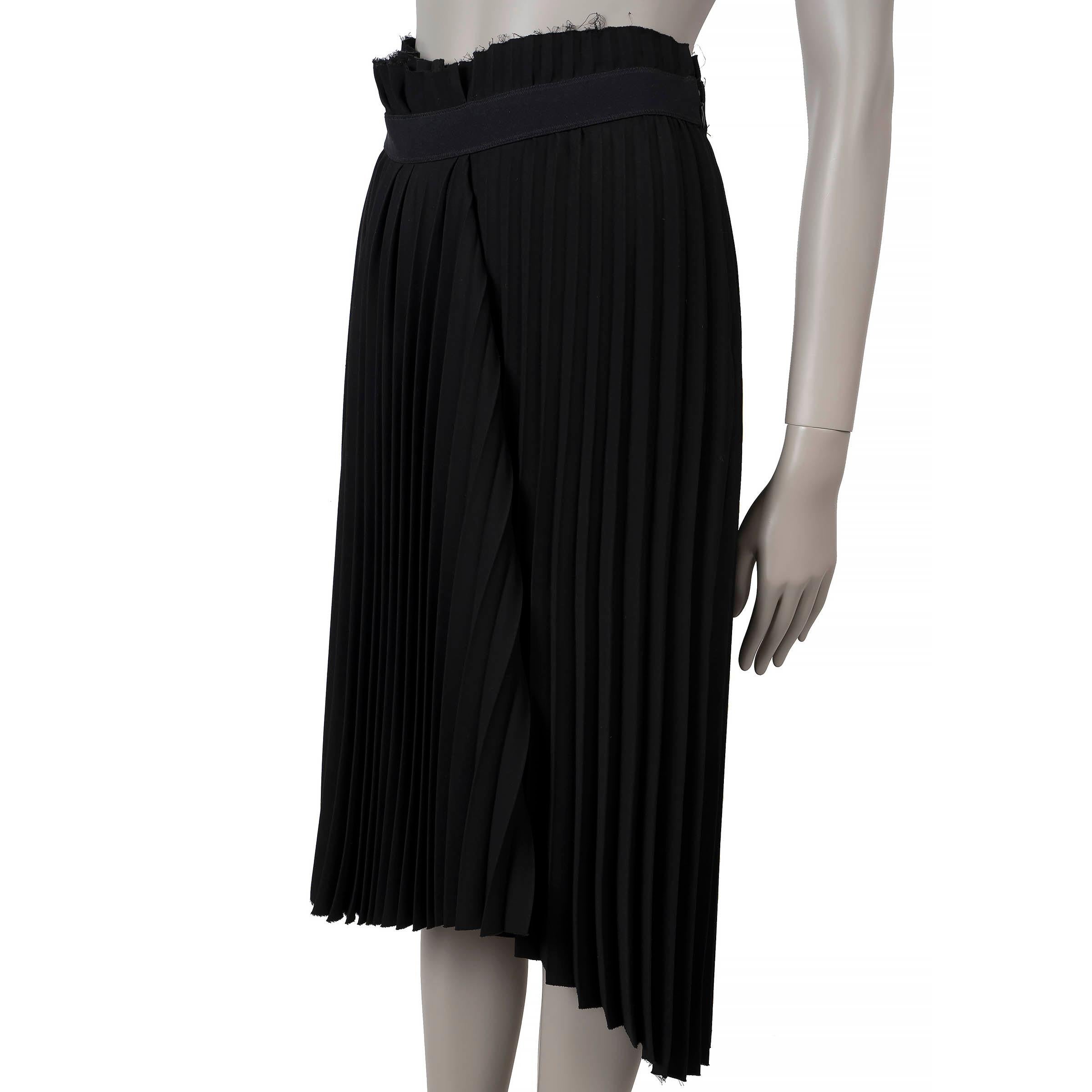This 100% authentic Balenciaga Fancy pleated skirt is crafted from black polyester (100%) and features a flared silhouette with a below-the-knee length and an asymmetric raw hem. The design is highlighted by a high paperbag waist with a logo band