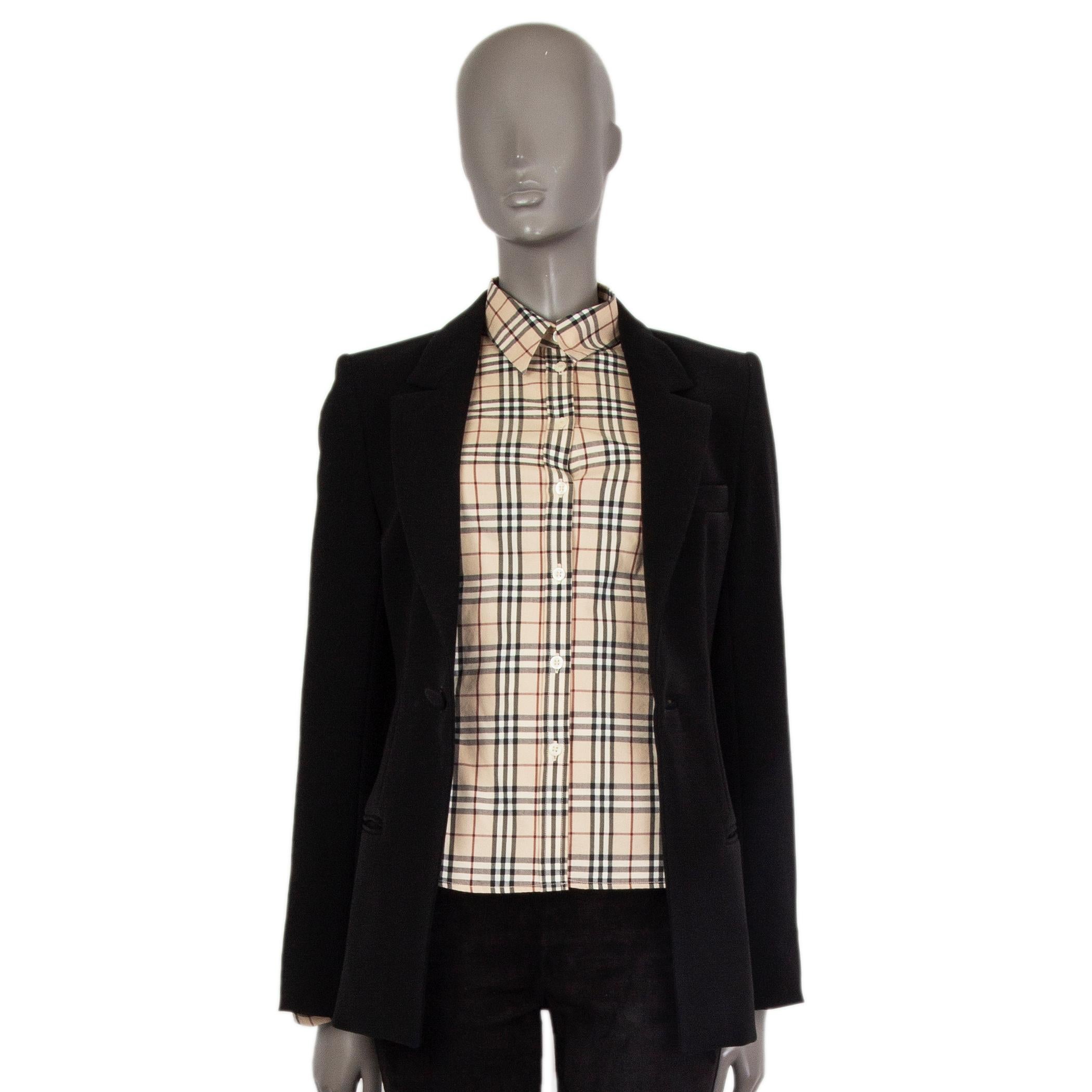 100% authentic Balenciaga open blazer in black polyester (100%). With notch collar, chest pocket, two welt pockets on the sides, slit cuffs, and slit on the back. Features decorative misplaced button and eyelet on the front, meant to be worn open.