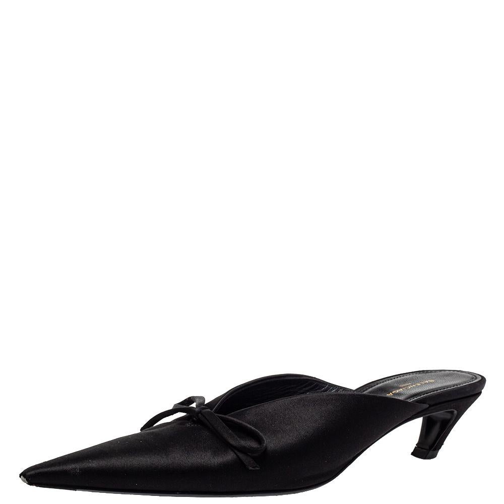 This pair of Balenciaga mules will add just the right trend to your closet. The pointed-toe sandals are covered in black satin and detailed with little bows on the vamps. They are elevated of 4 cm kitten heels and finished with comfortable leather