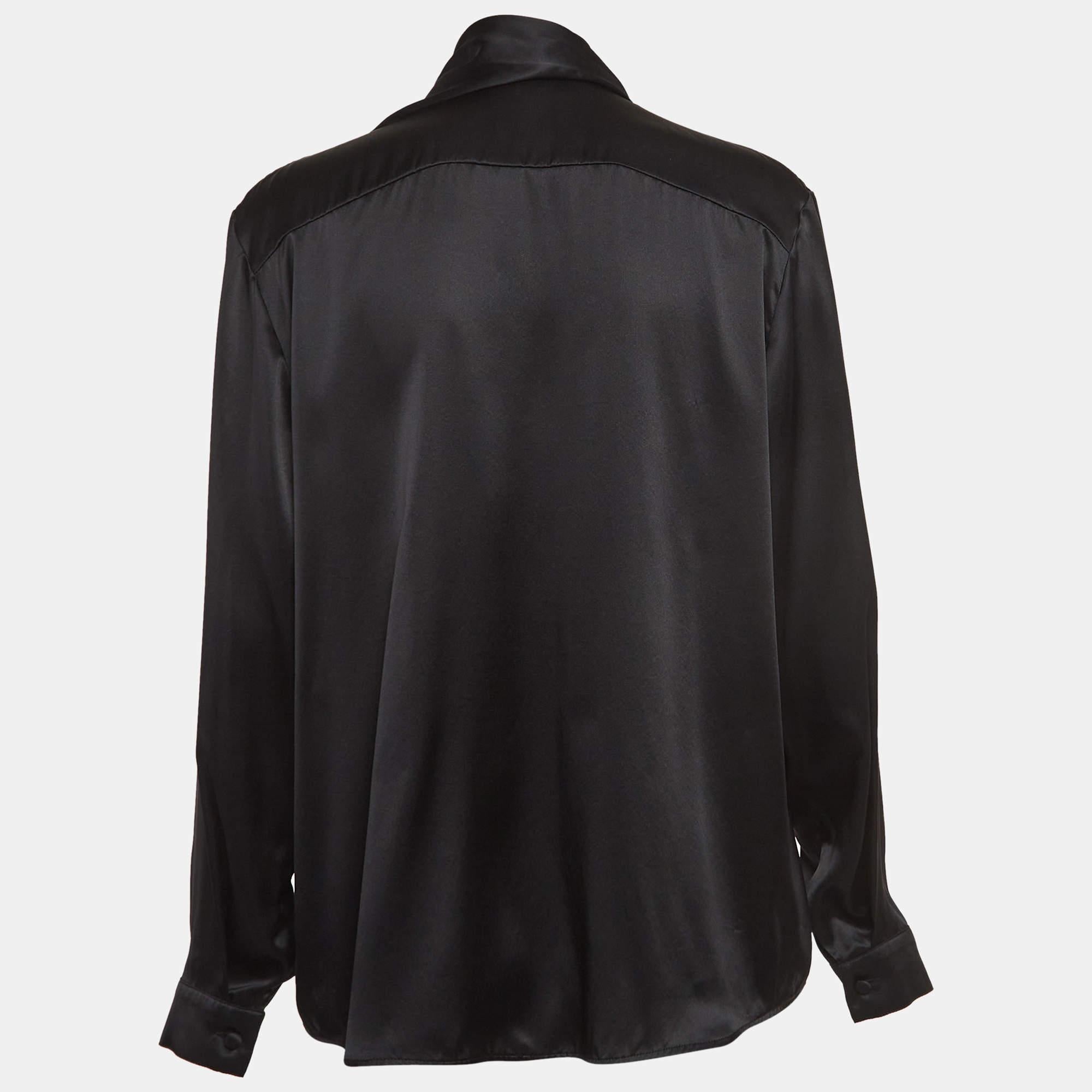 The Balenciaga shirt exudes sophistication and elegance. Crafted from luxurious satin silk, it features a unique tie-up neck design and a sleek button-front silhouette. This shirt effortlessly combines contemporary style with timeless refinement,