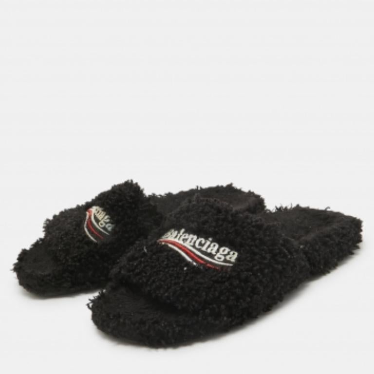 Mit diesen flachen Balenciaga Shearling-Fell-Slides sind Sie den ganzen Tag über bequem unterwegs. Sie sind in Schwarz gehalten und mit einer unübersehbaren Signatur auf dem Obermaterial versehen.