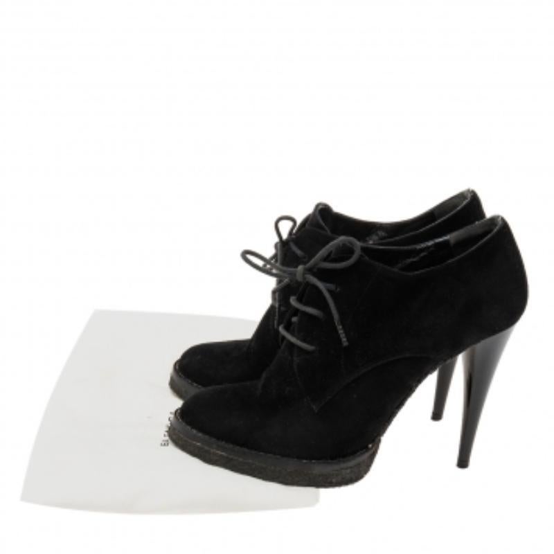 A sporty flair and a chic appeal characterize these stunning boots from the House of Balenciaga. They are designed using black suede into an ankle-length profile. They showcase lace-ups on the vamps, platforms, and slender heels. Elevate the look of