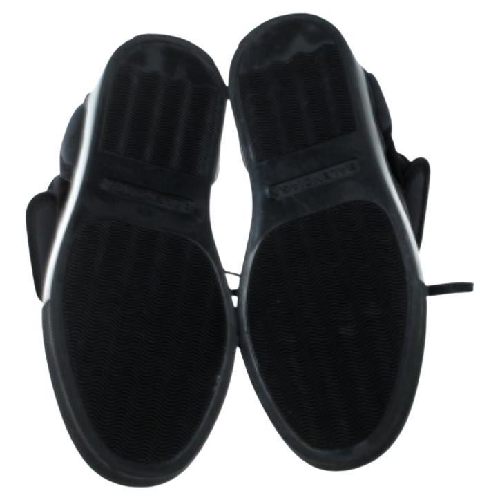 Diese High-Top-Sneakers von Balenciaga sind so schick, dass Sie sie gerne bei Ihren lustigen Ausflügen mit Freunden tragen werden! Die schwarzen Sneakers sind aus Leder, Samt und Stoff gefertigt und haben eine runde Schuhspitze. Sie zeigen sich mit