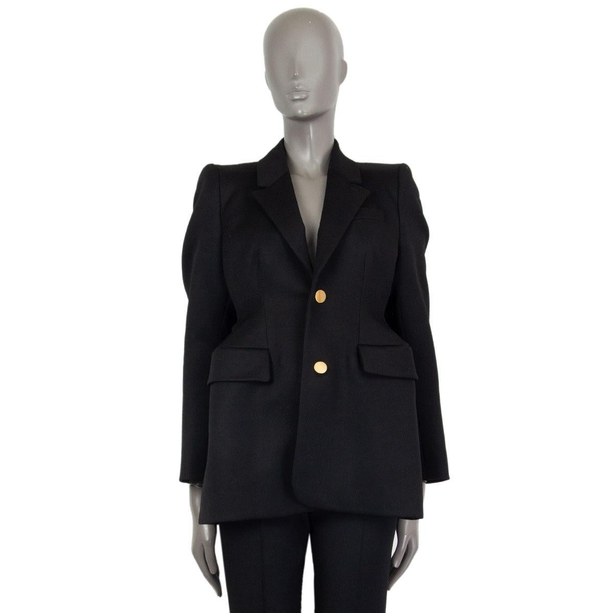 authentic Balenciaga single breasted hourglass blazer in black wool (100%) with padded shoulders and structured hips. Closes with two buttons on the front, has flap pockets and gold-tone metal buttons. Lined in black cupro (100%). Has been worn and