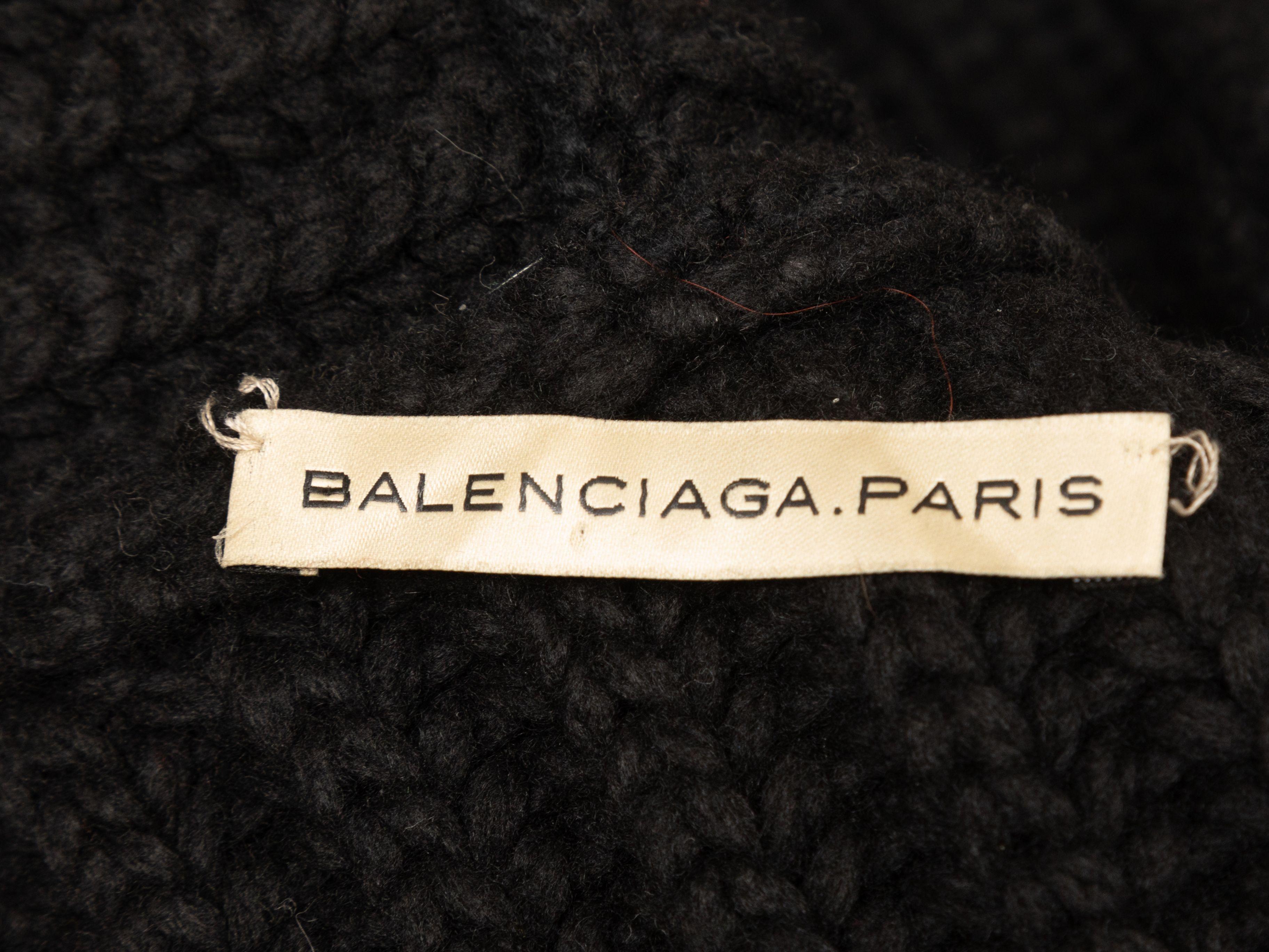 Product Details: Black wool rib knit layered vest by Balenciaga. V-neck. Closures at center front. Designer size 38. 38