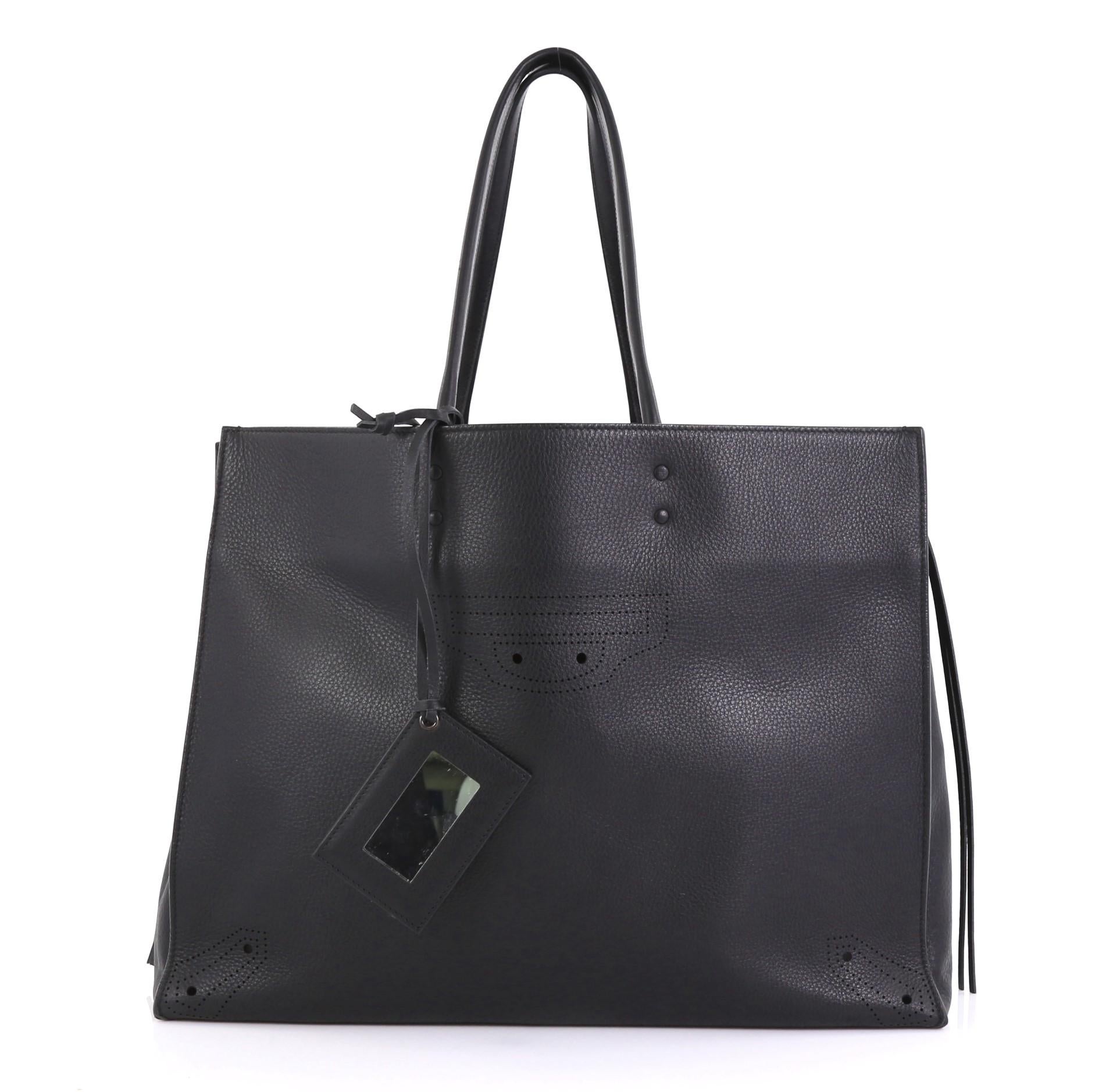 This Balenciaga Blackout A4 Zip Around Tote Leather Large, crafted in black leather, features slim handles, zip sides that allows the bag to expand, and aged gold-tone hardware. It opens to a black leather interior with zip pocket. 

Estimated