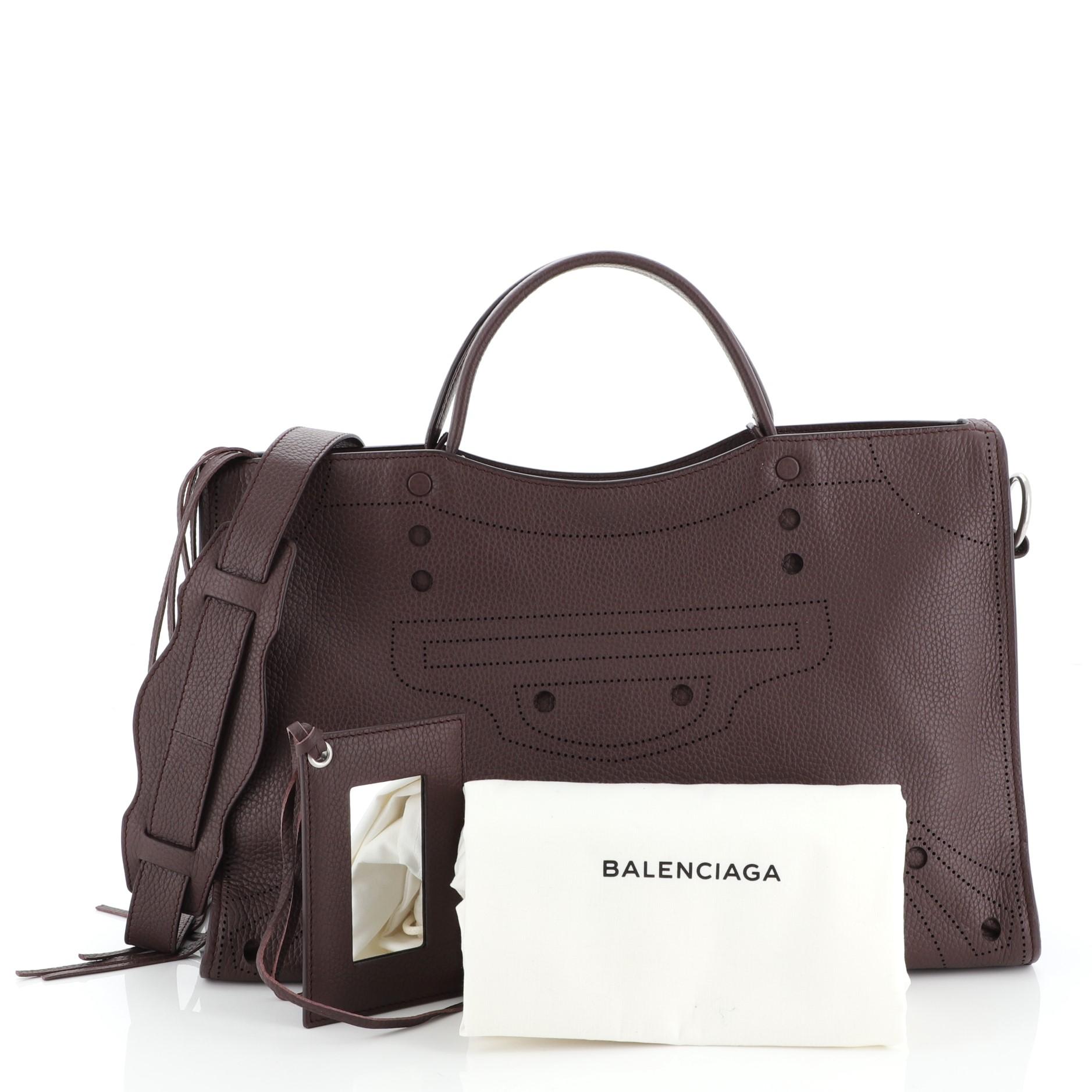 This Balenciaga Blackout City Bag Leather Medium, crafted in purple leather, features dual leather handles and matte silver-tone hardware. Its zip closure opens to a purple leather and suede interior with zip and snap pockets. 

Estimated Retail