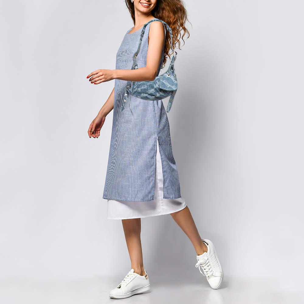 Ensure your days essentials are in order and your outfit is complete with this Balenciaga XS Le Cagole shoulder bag. Crafted using monogram denims the bag has a single handle gunmetal tone metal accents and a fabric lined interior.