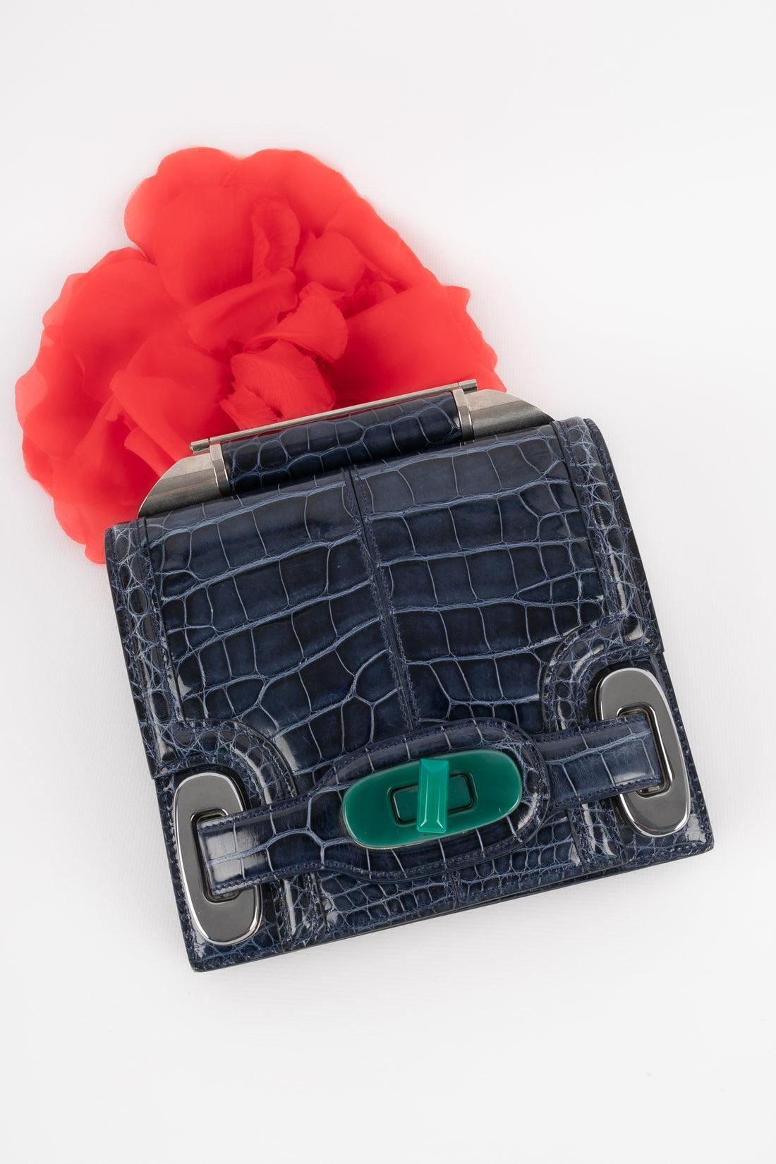 Balenciaga - Blaue Tasche aus exotischem Leder mit silbernen Metallelementen und einem grünen Bakelitverschluss. Tasche mit einer Seriennummer.

Zusätzliche Informationen:
Zustand: Sehr guter Zustand
Abmessungen: Höhe: 16 cm - Länge: 17 cm - Tiefe: