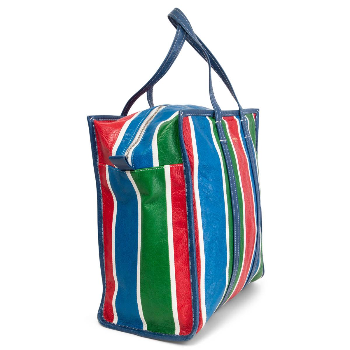 100% authentic Balenciaga Large Bazar shopping bag striped in red, blue, green and white wrinkled lambskin. Opens with a zipper on top and is lined in black canvas with a zipper pocket against the back and an open pocket against the front.  Has been